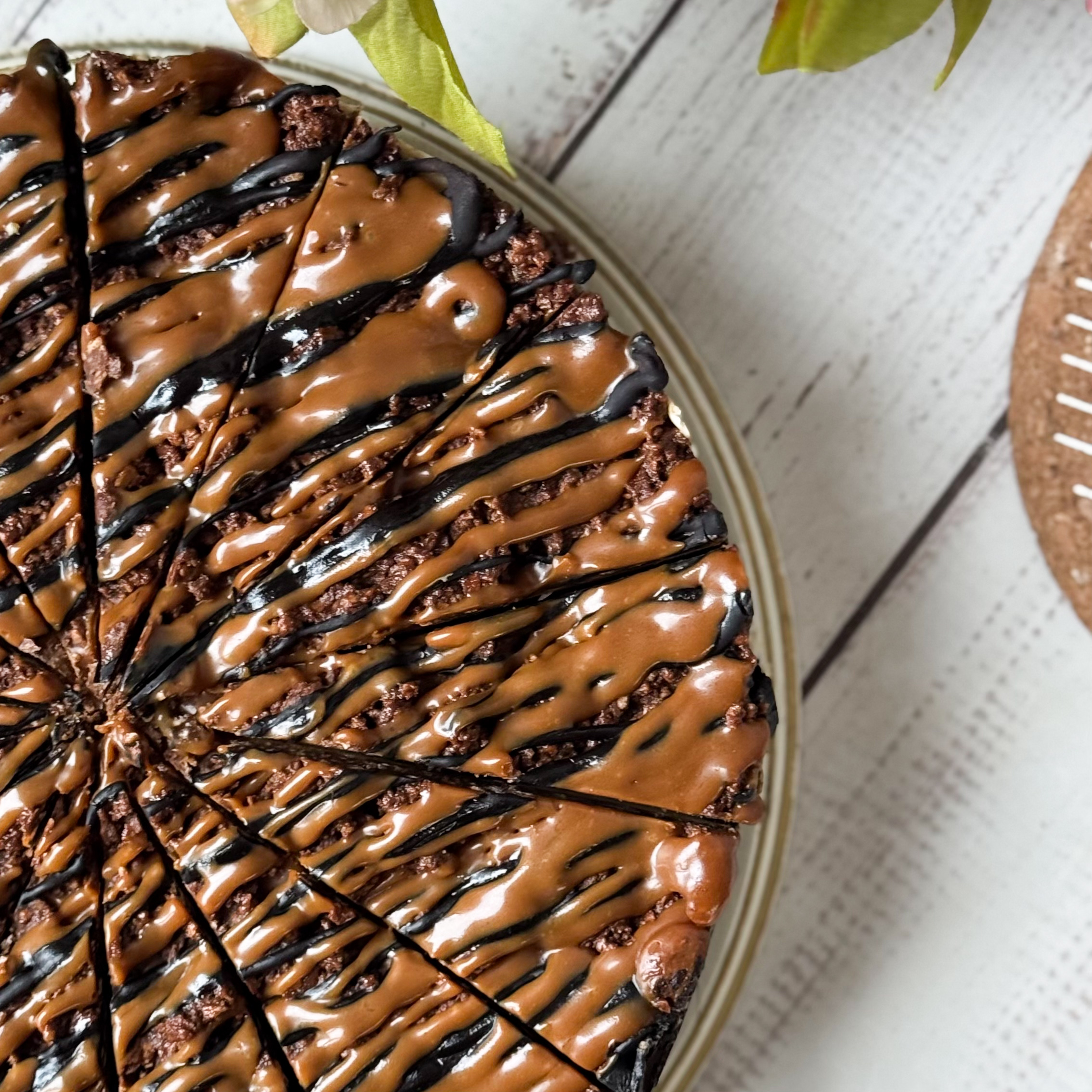 Классический сливочно-сырный чизкейк Нью-Йорк на подложке из песочного шоколадного теста с начинкой из шоколадного ганаша и карамельного кранча. Сверху чизкейк украшен карамельным кранчем, арахисом, карамелью и шоколадным муссом. изображение 5