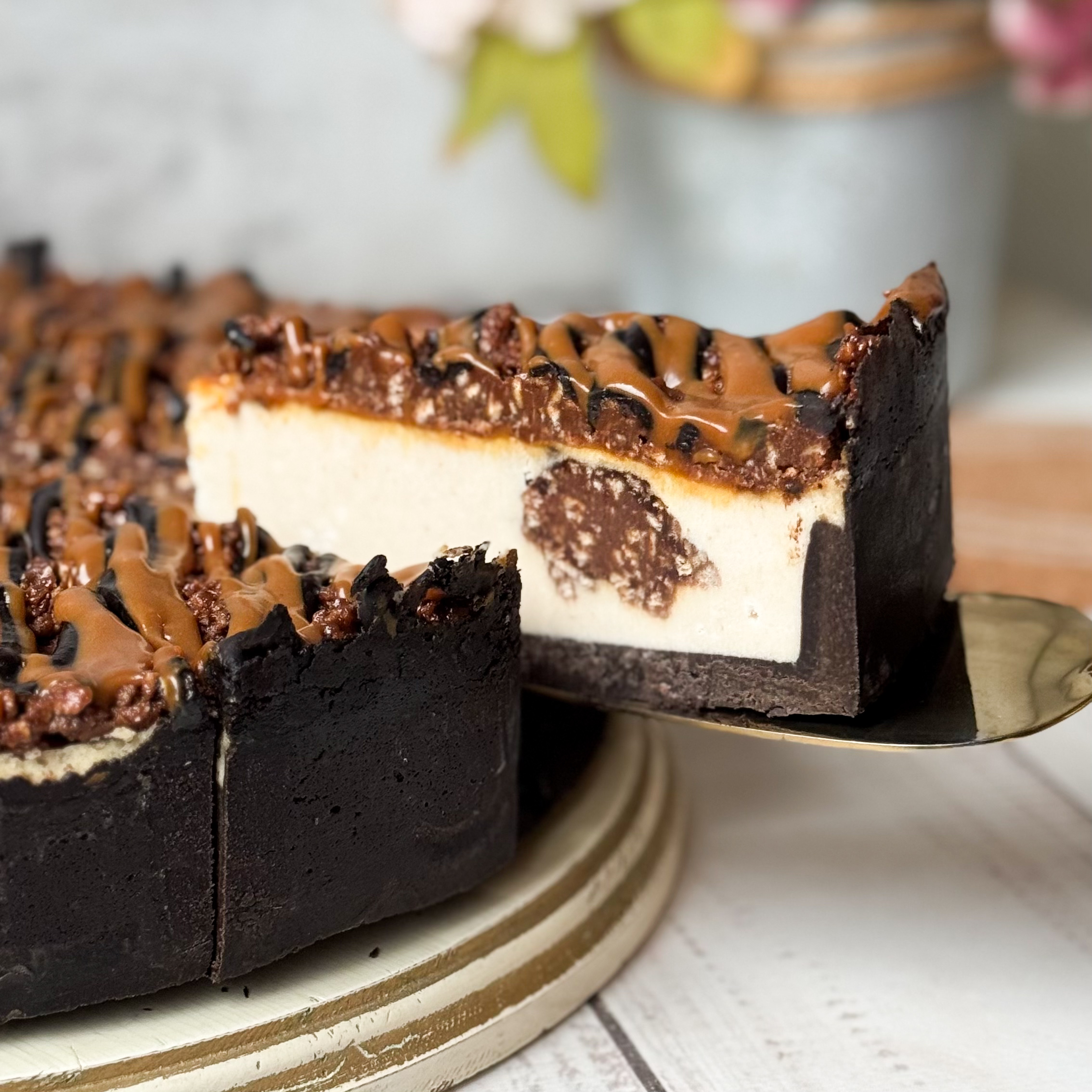 Классический сливочно-сырный чизкейк Нью-Йорк на подложке из песочного шоколадного теста с начинкой из шоколадного ганаша и карамельного кранча. Сверху чизкейк украшен карамельным кранчем, арахисом, карамелью и шоколадным муссом. изображение 7