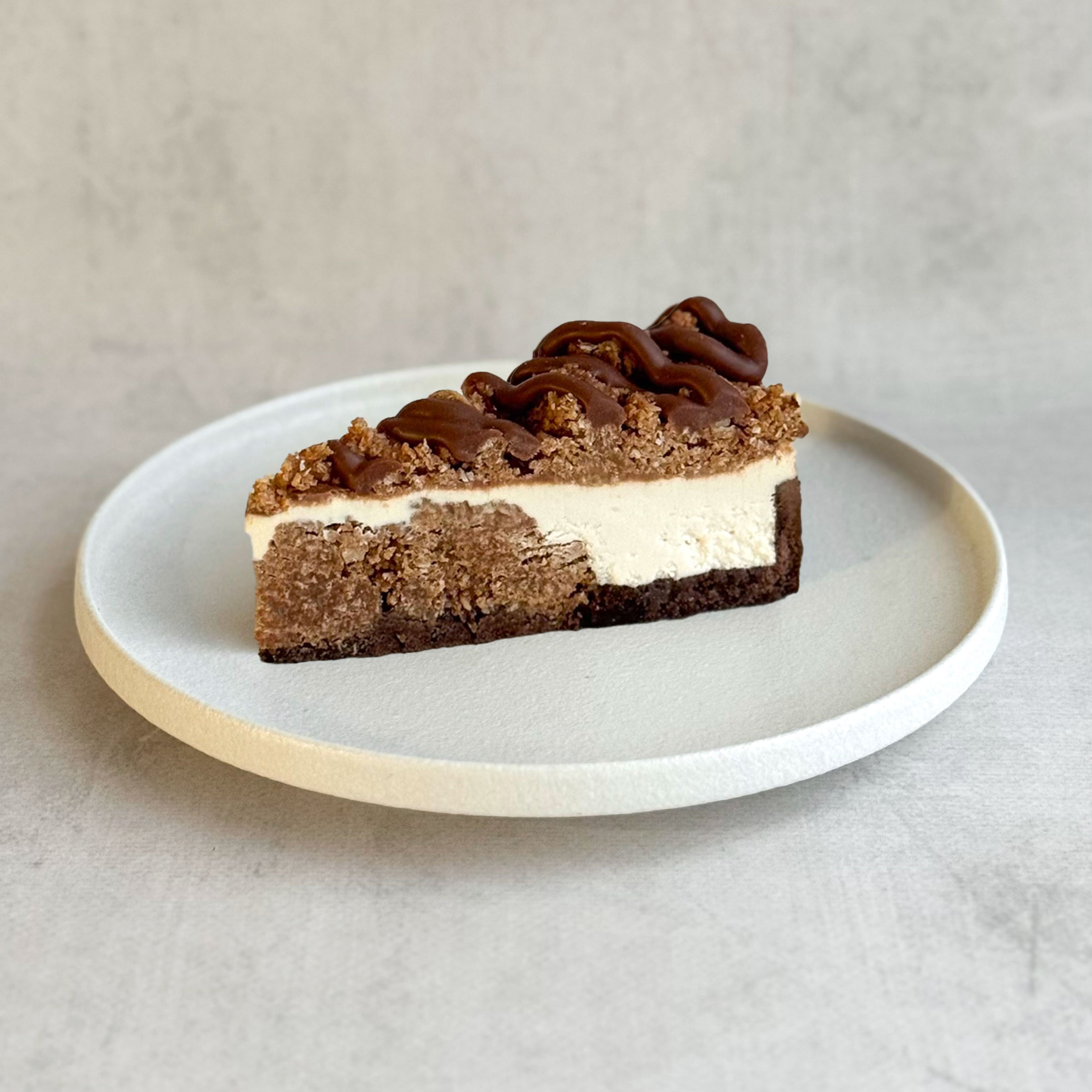 Нежный чизкейк из творожного сыра с начинкой из мягкого кокосового кранча с мякотью кокоса на песочно-шоколадной подложке. Сверху украшен кокосовым кранчем и залит карамелью. изображение 1