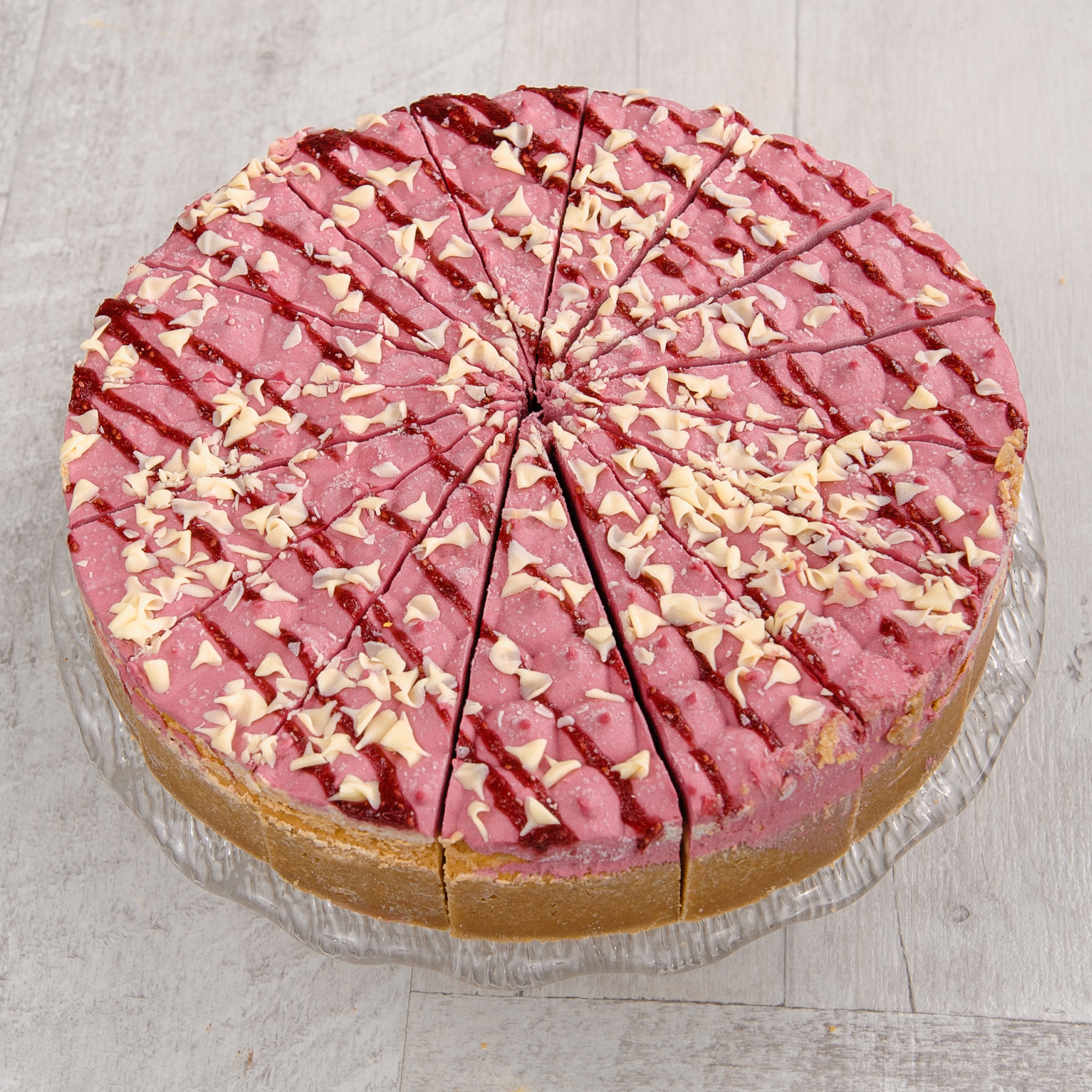 Чизкейк из творожного сыра с прослойкой из малинового мусса и малинового пюре на песочной подложке. Сверху чизкейк украшен пиками из мусса и белым шоколадом. изображение 2