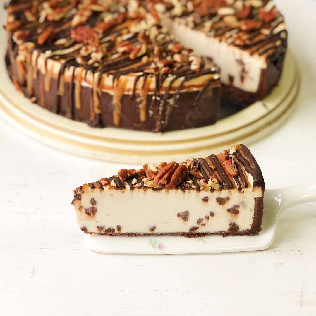 Классический чизкейк Нью-Йорк с шоколадными криспами на песочно-шоколадной основе. Сверху чизкейк залит карамелью и шоколадом, а также усыпан дробленым грецким орехом изображение 1