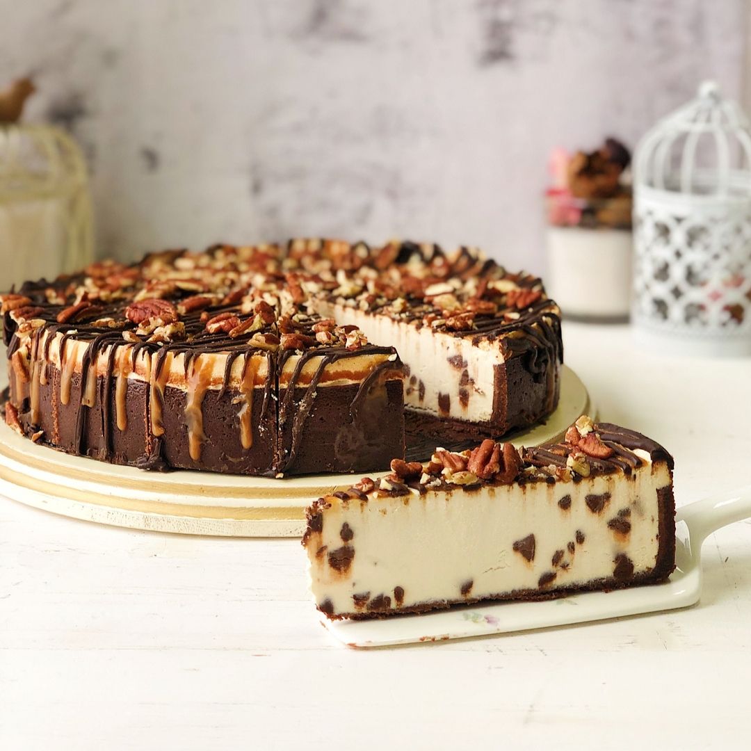 Классический чизкейк Нью-Йорк с шоколадными криспами на песочно-шоколадной основе. Сверху чизкейк залит карамелью и шоколадом, а также усыпан дробленым грецким орехом изображение 2