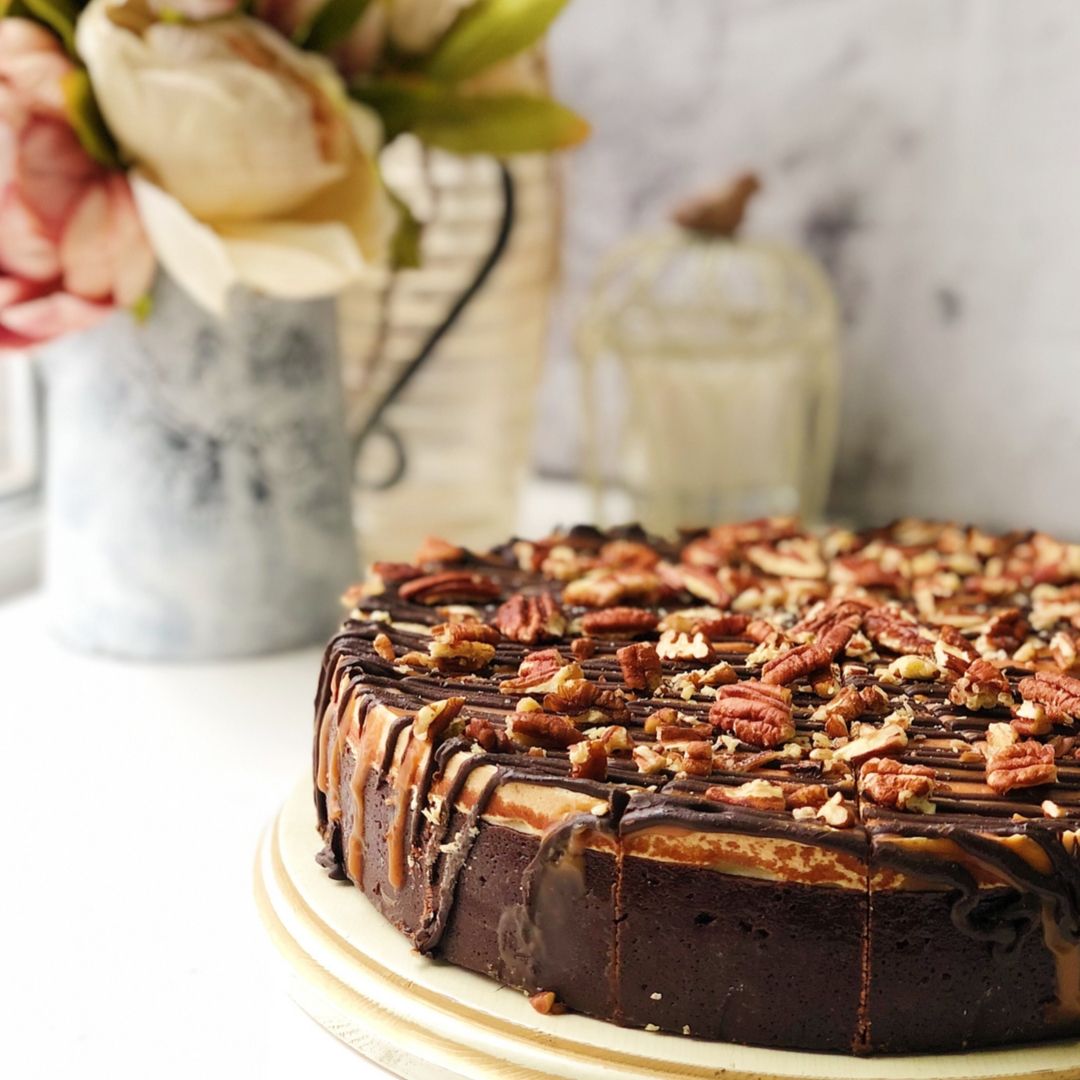 Классический чизкейк Нью-Йорк с шоколадными криспами на песочно-шоколадной основе. Сверху чизкейк залит карамелью и шоколадом, а также усыпан дробленым грецким орехом изображение 5