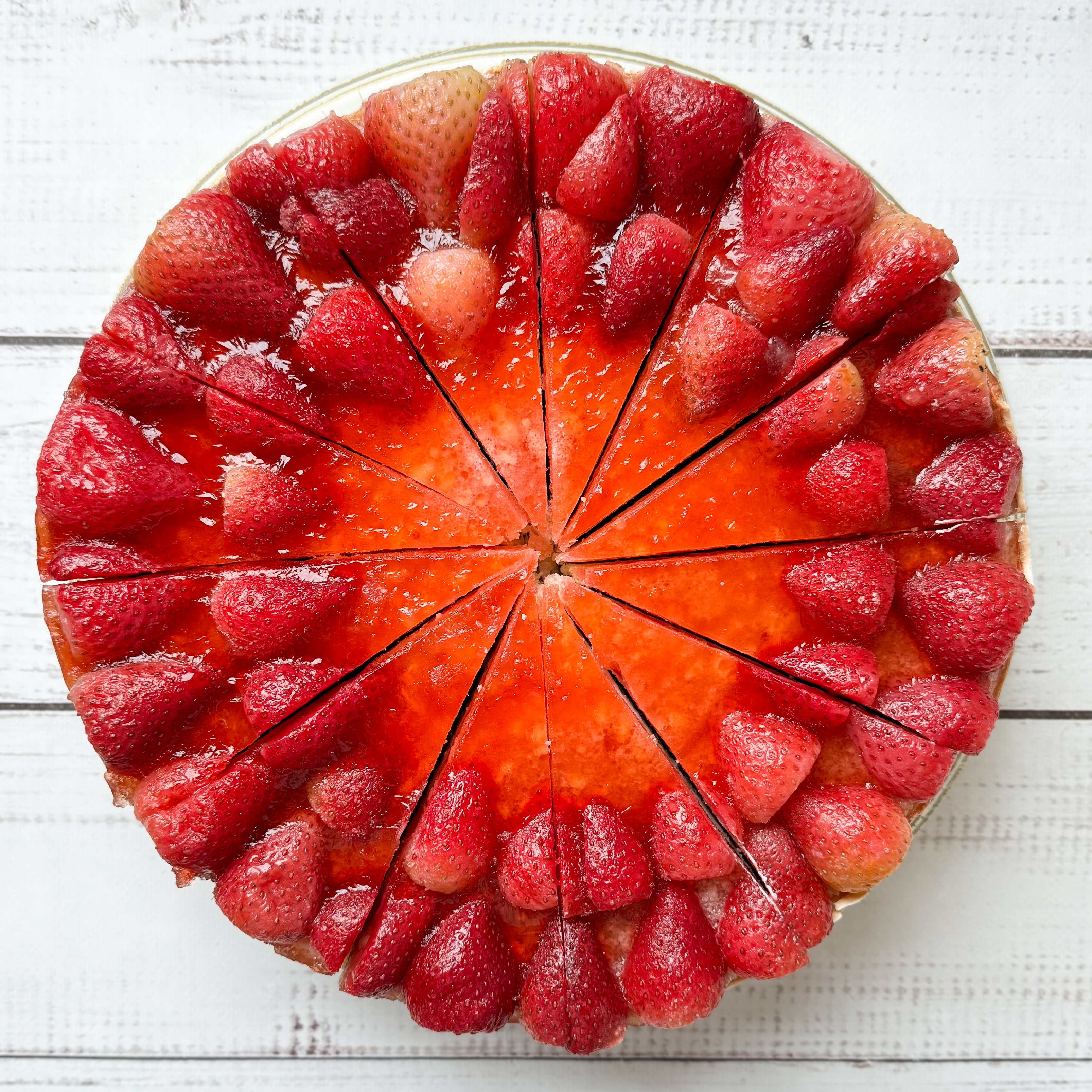 Нежнейший чизкейк из творожного сыра на сливочно-песочном корже, усыпанный ягодами свежей клубники, выращенной под солнцем в естественных климатических условиях. изображение 2