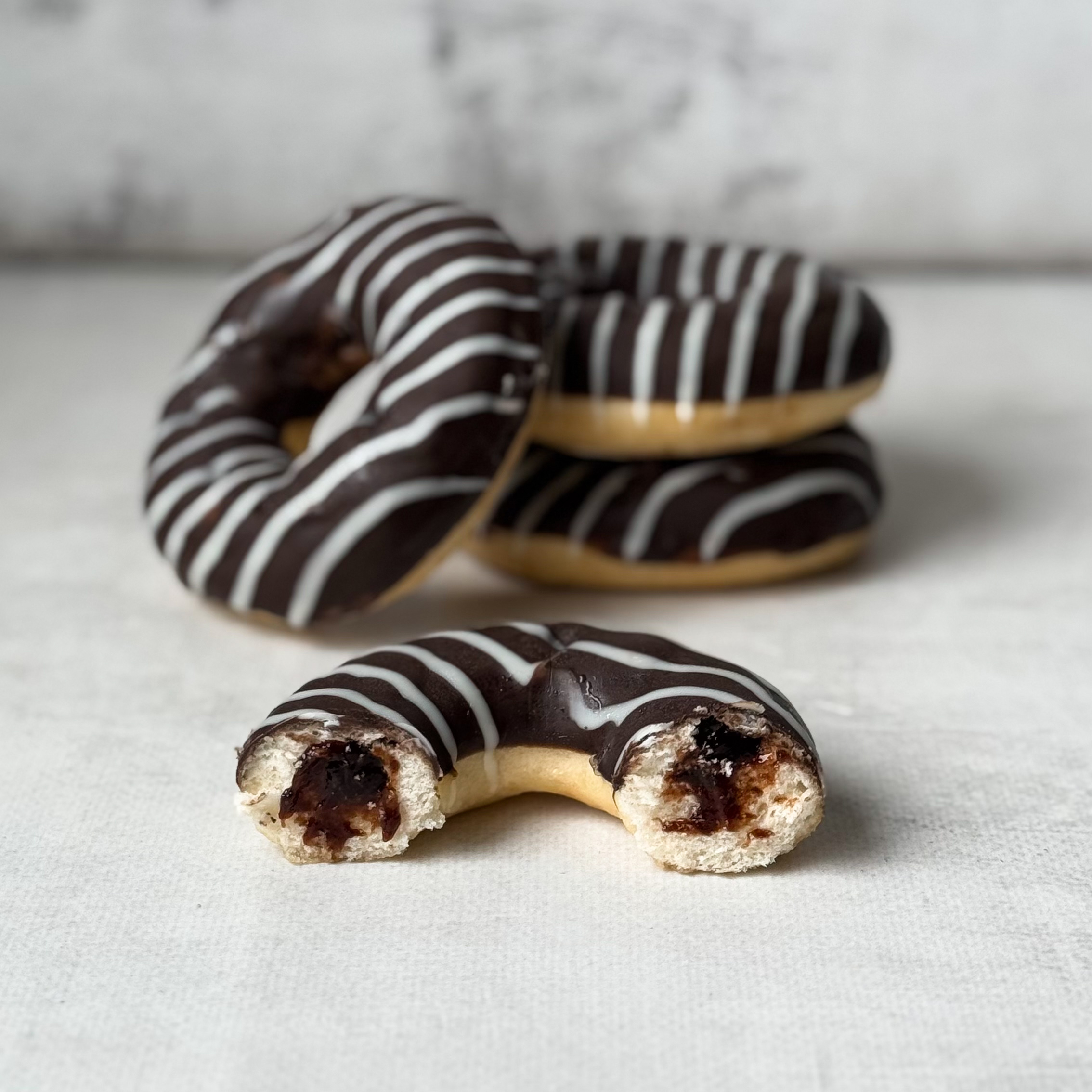 Пончик-донатс с шоколадной начинкой и шоколадной кондитерской глазурью изображение 1