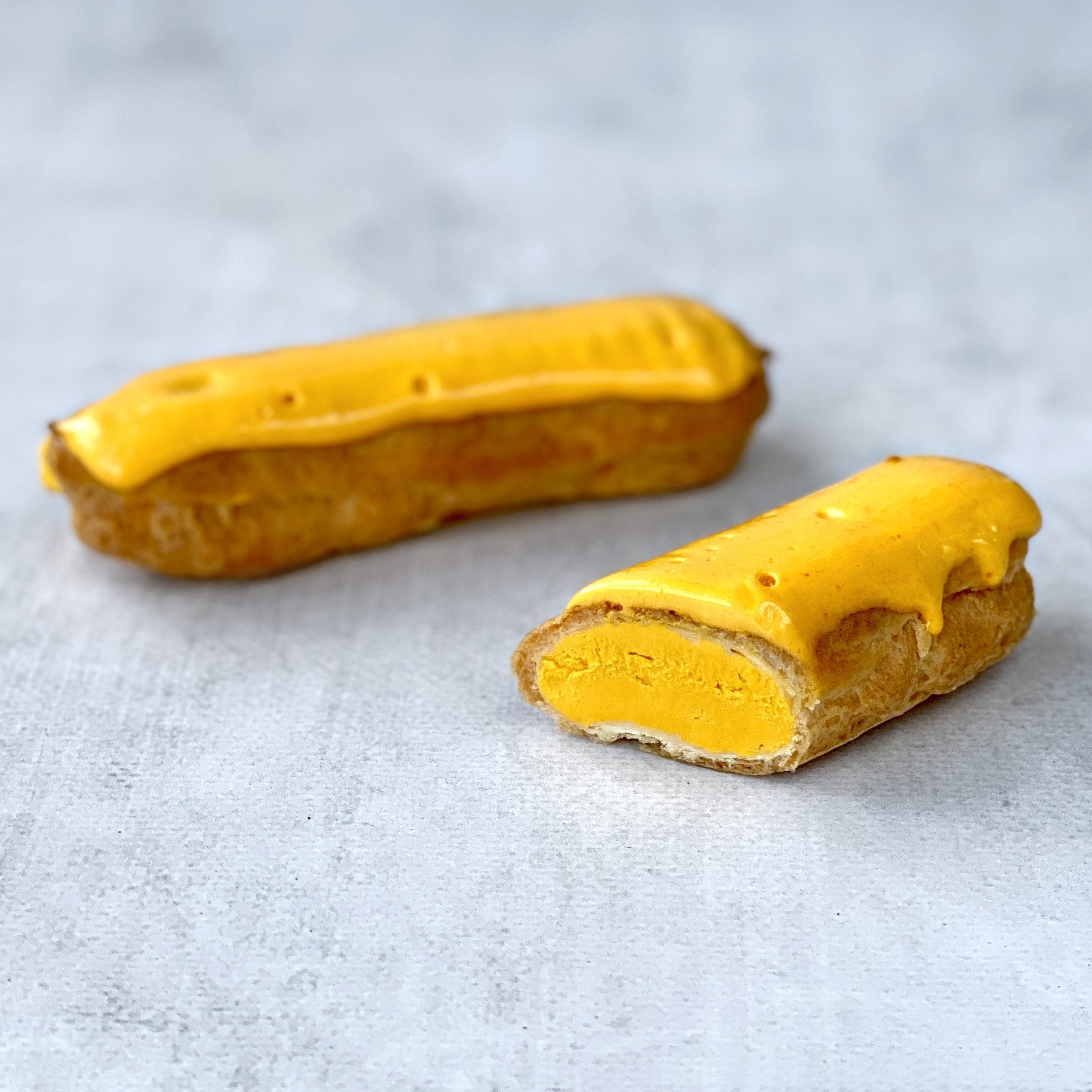 Эклер с начинкой из пюре маракуйи, манго и кремом из взбитых сливок, покрытый помадкой с тропическим вкусом изображение 3