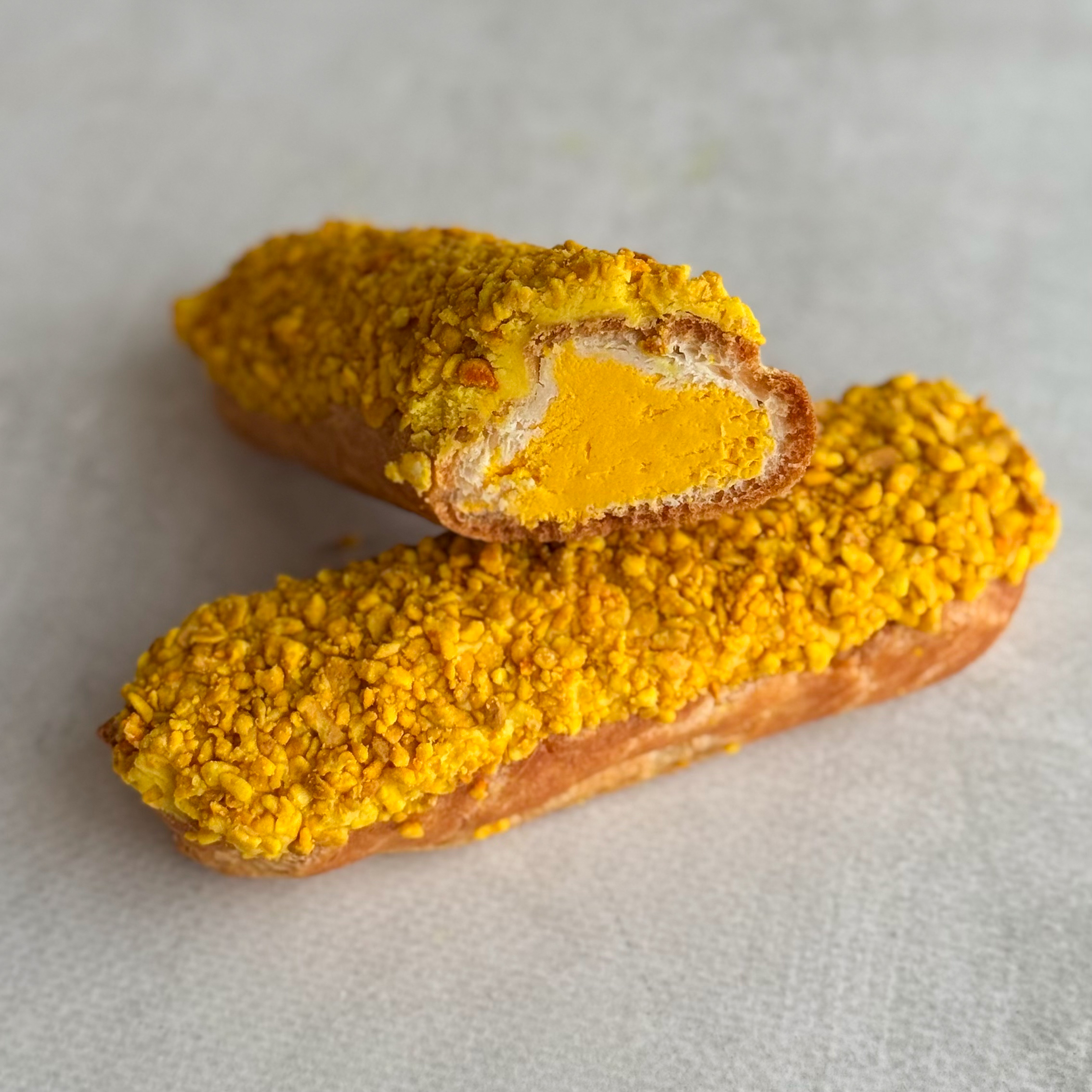 Эклер с начинкой из пюре маракуйи, манго и кремом из взбитых сливок, покрытый помадкой и посыпкой с тропическим вкусом изображение 1