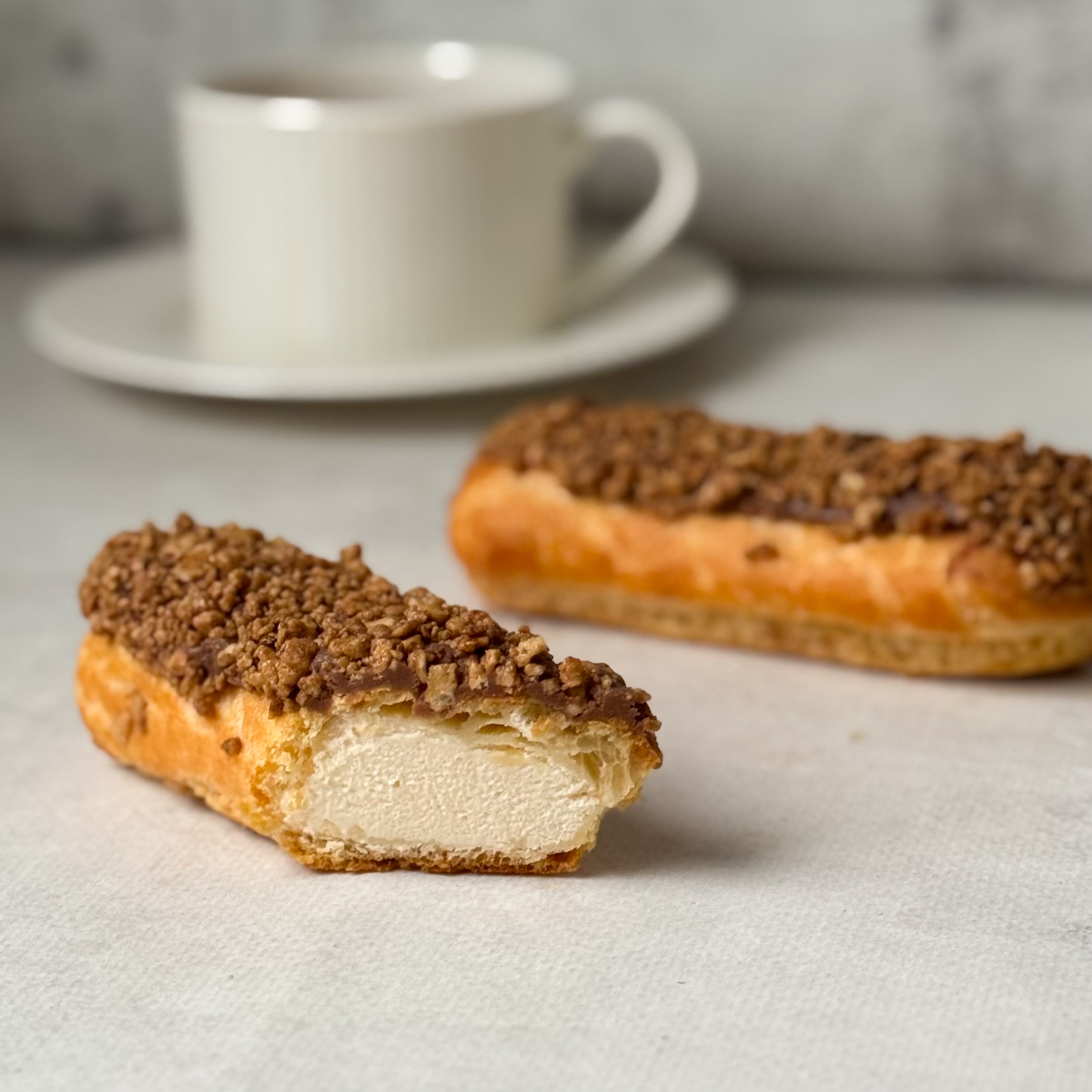 Ванильный эклер с начинкой из сливочного крема, покрытый шоколадной помадкой с посыпкой изображение 1