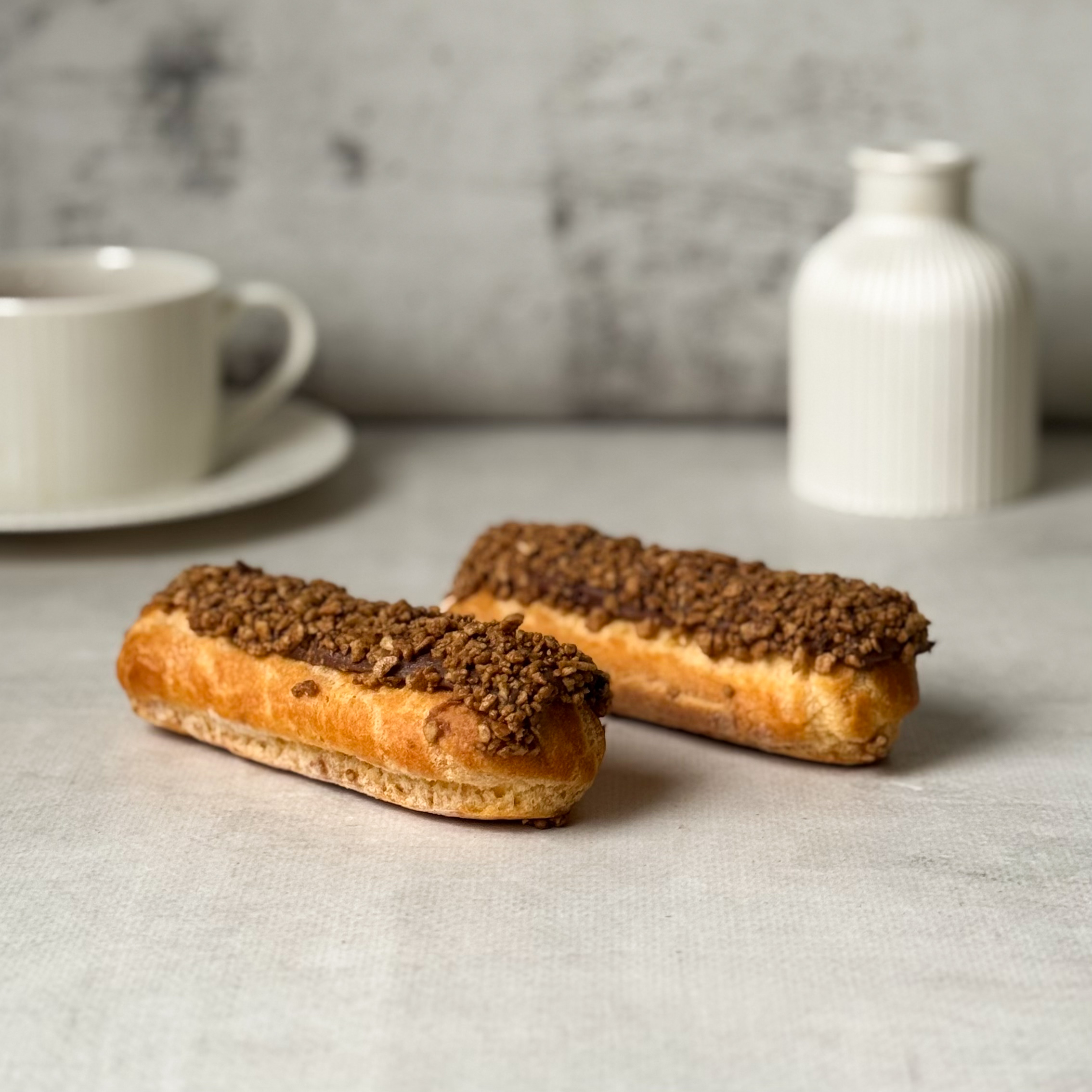 Ванильный эклер с начинкой из сливочного крема, покрытый шоколадной помадкой с посыпкой изображение 3