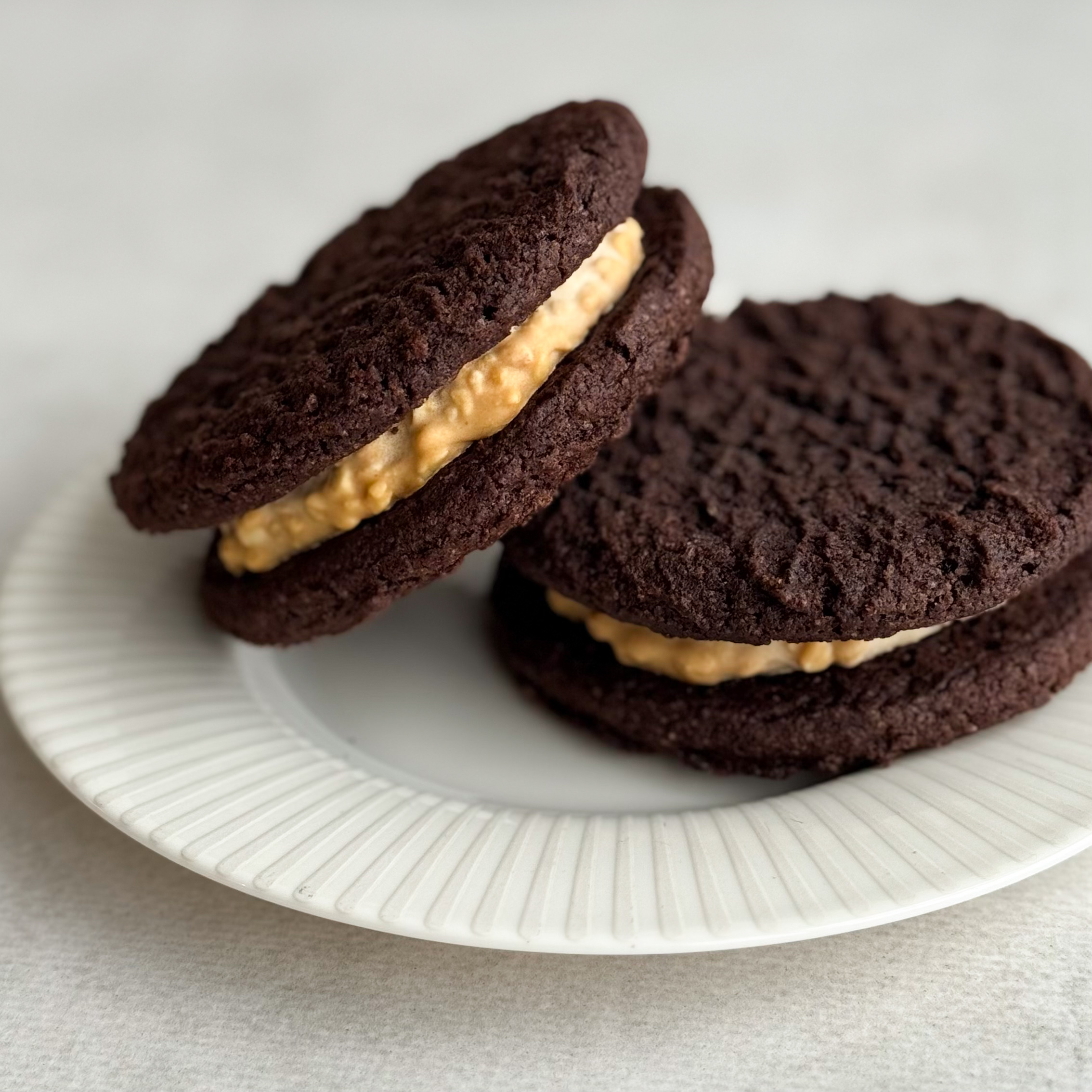 Вупи пай «Брауни с арахисовой пастой» - это два мягких шоколадных печенья брауни с насыщенным какао и нежной кремовой начинкой из арахисовой пасты. Идеальный баланс сладости и легкой ореховой нотки. изображение 6