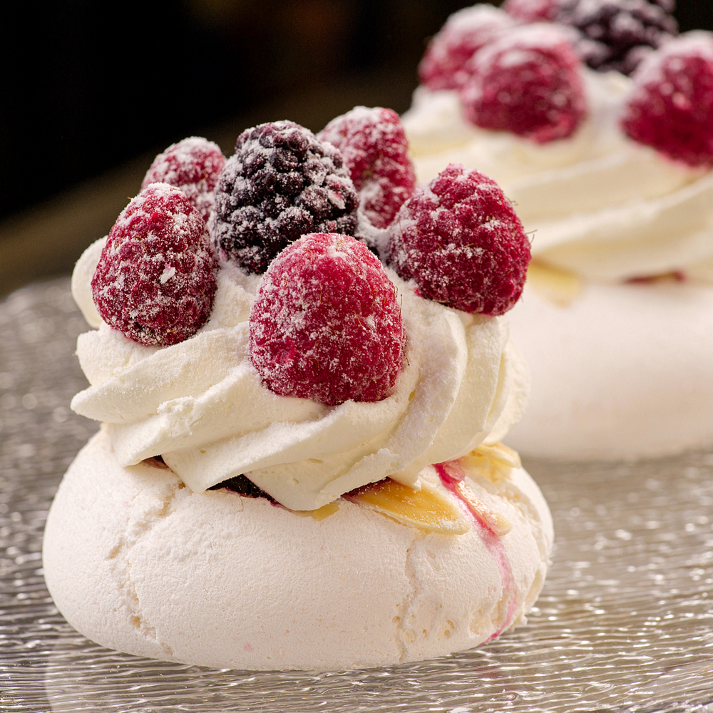 Воздушное безе с вишнёвой сердцевиной, прослойкой из лепестков миндаля и сливочным кремом. Сверху украшено свежими ягодами малины. изображение 1