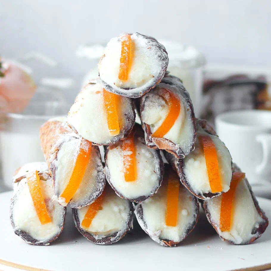 Хрустящая трубочка, покрытая изнутри шоколадом, заполнена начинкой - легким кремом на основе сыра Рикотта. Край трубочки украшен апельсиновыми цукатами. изображение 3