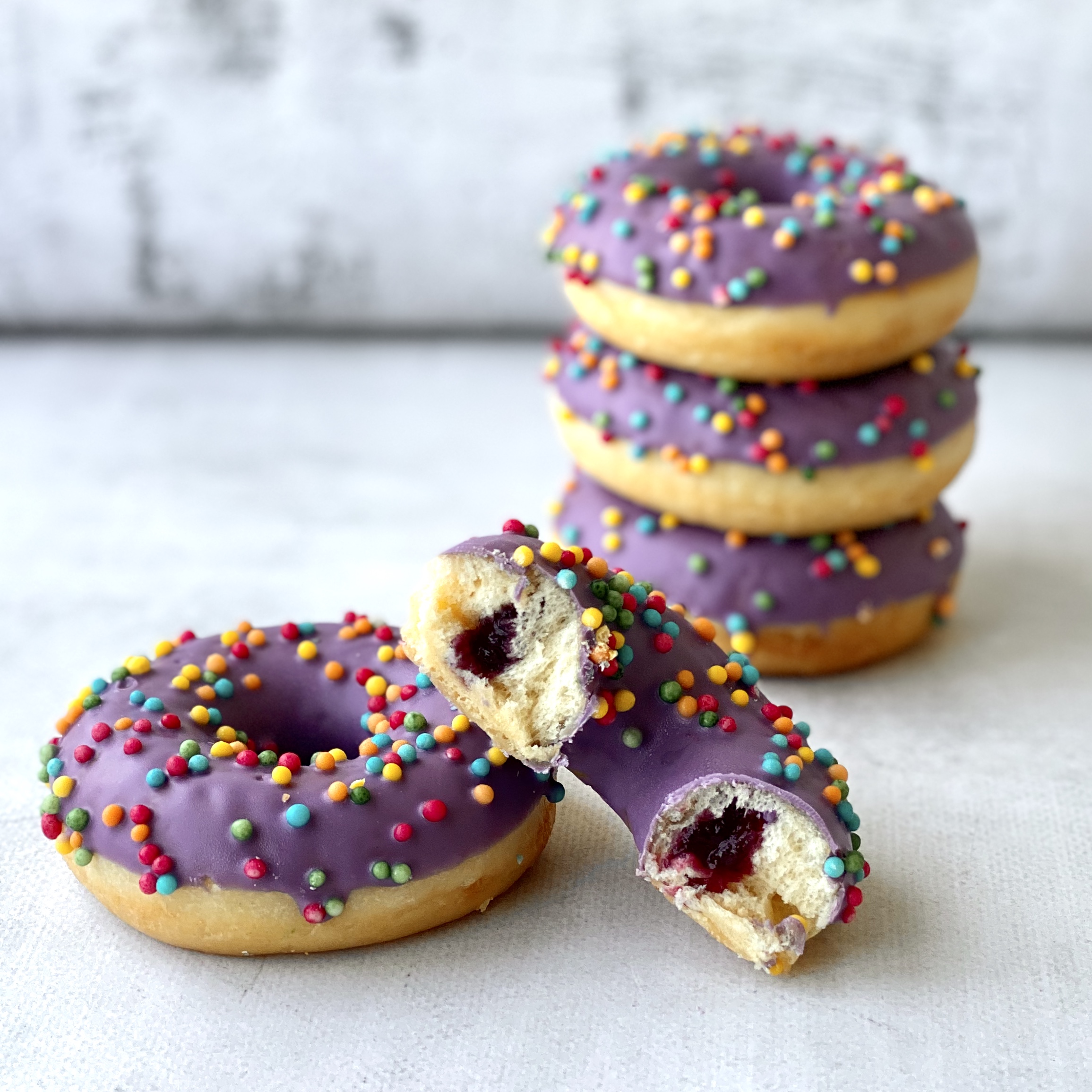 Пончик с черничной начинкой в цветной глазури и хрустящими шариками изображение 1