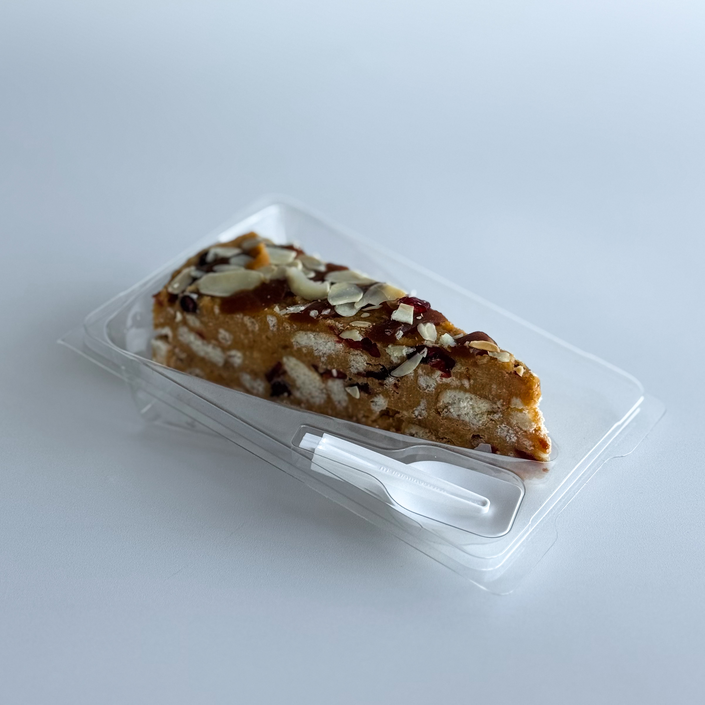 Сочный песочно-карамельный торт с сушеной клюквой и кусочками печенья. Сверху торт украшен волнами мягкой карамели, лепестками миндаля и клюквой.  изображение 4