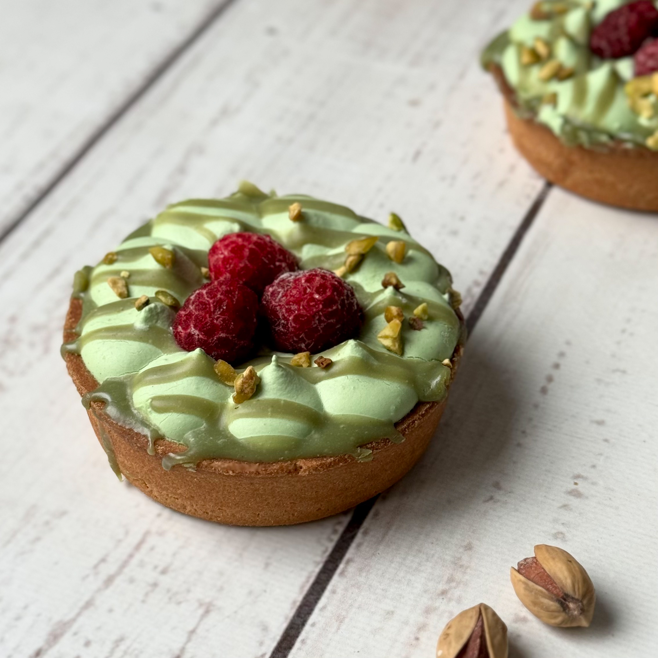 Фисташковый крем, малиновая прослойка в корзиночке из песочного теста. Сверху тарталетка украшена ягодами малины и дроблёной фисташкой. изображение 4