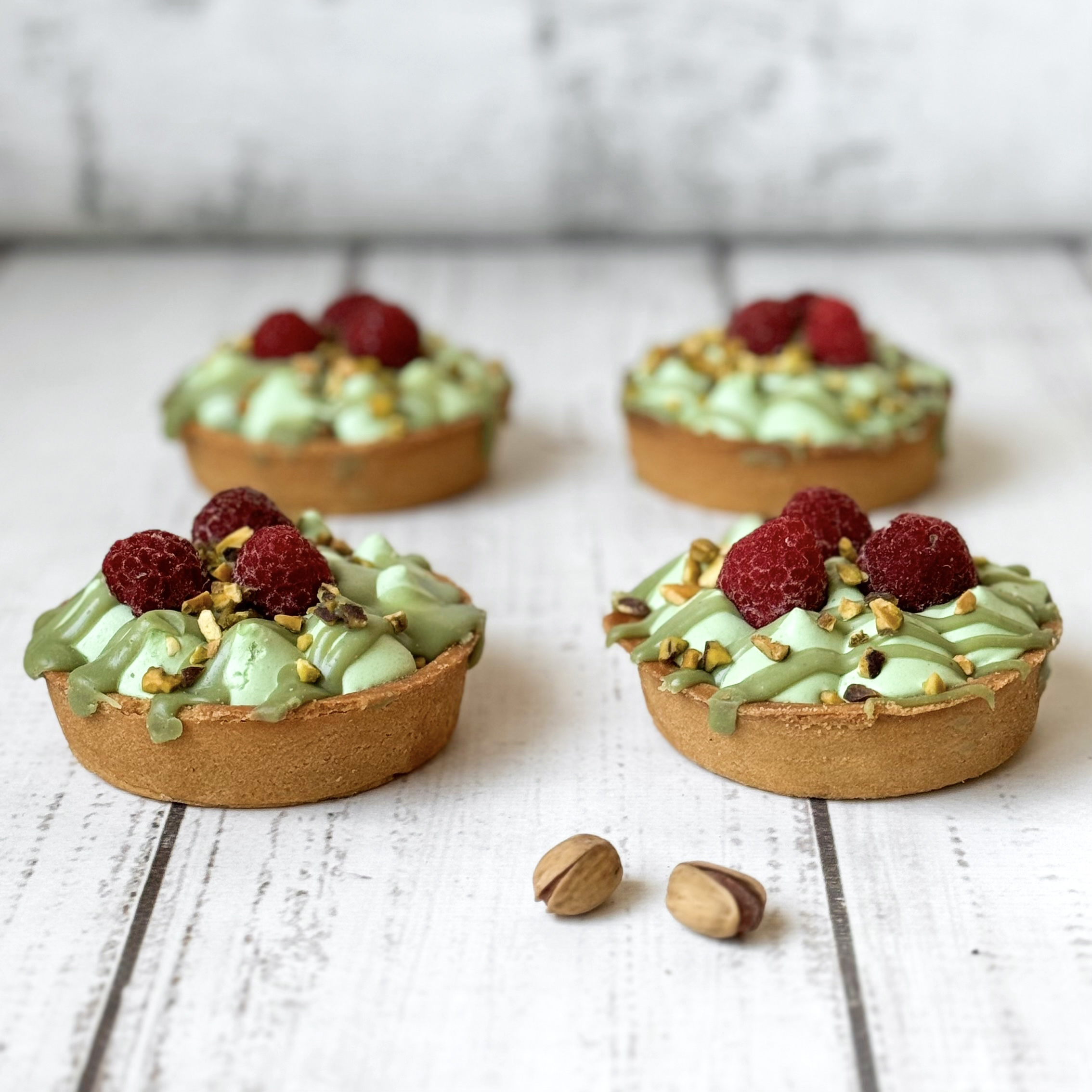 Фисташковый крем, малиновая прослойка в корзиночке из песочного теста. Сверху тарталетка украшена ягодами малины и дроблёной фисташкой. изображение 4