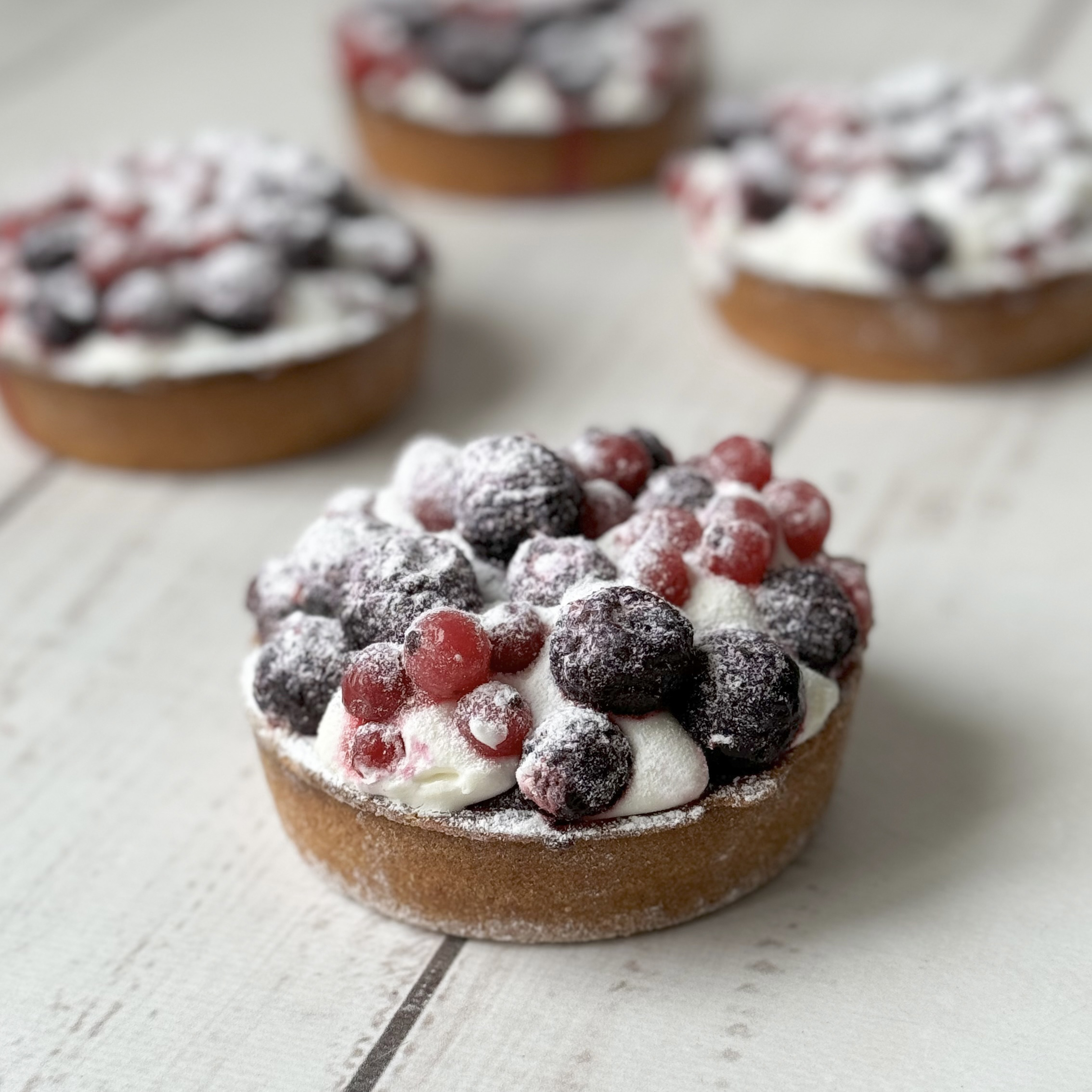 Ягодная тарталетка с начинкой из пюре чёрной смородины, взбитыми сливками и ягодами чёрной смородины в корзиночке из песочного теста. изображение 2