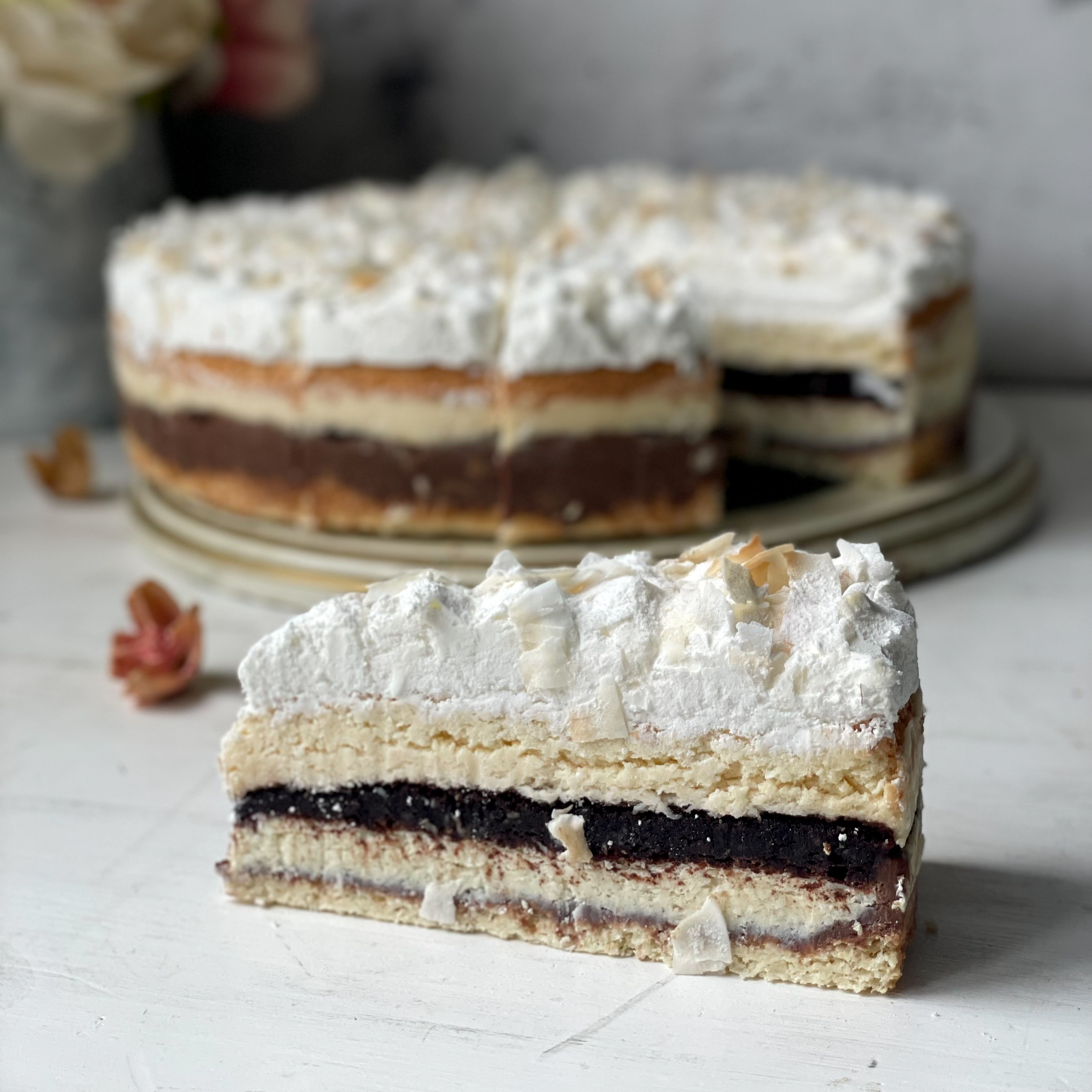 Изысканный торт из слоев кокосового бисквита, крема на основе сыра Маскарпоне и насыщенного шоколадного слоя. Сверху торт украшен обжаренным кокосовым кранчем. изображение 1