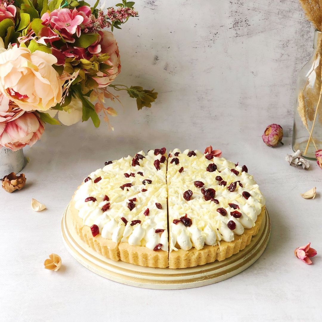 Пирог с брусничной начинкой и начинкой из белого шоколада, брусникой, взбитыми сливками, украшенный белом шоколадом и клюквой. изображение 2