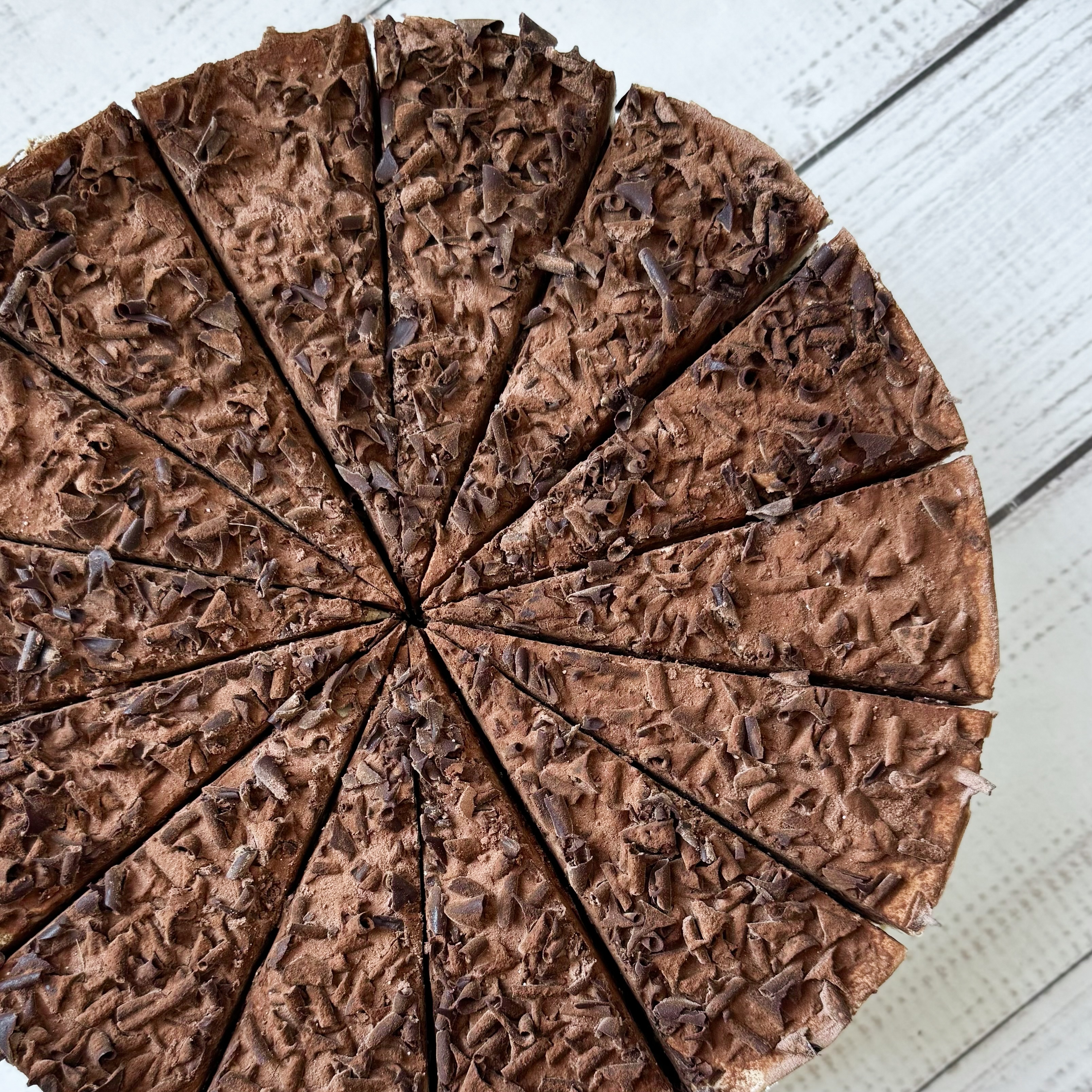 Слои шоколадного бисквита, пропитанного вишневым сиропом, чередуются со слоями крема из свежих сливок и сочных вишен. Украшен шоколадной стружкой. изображение 6