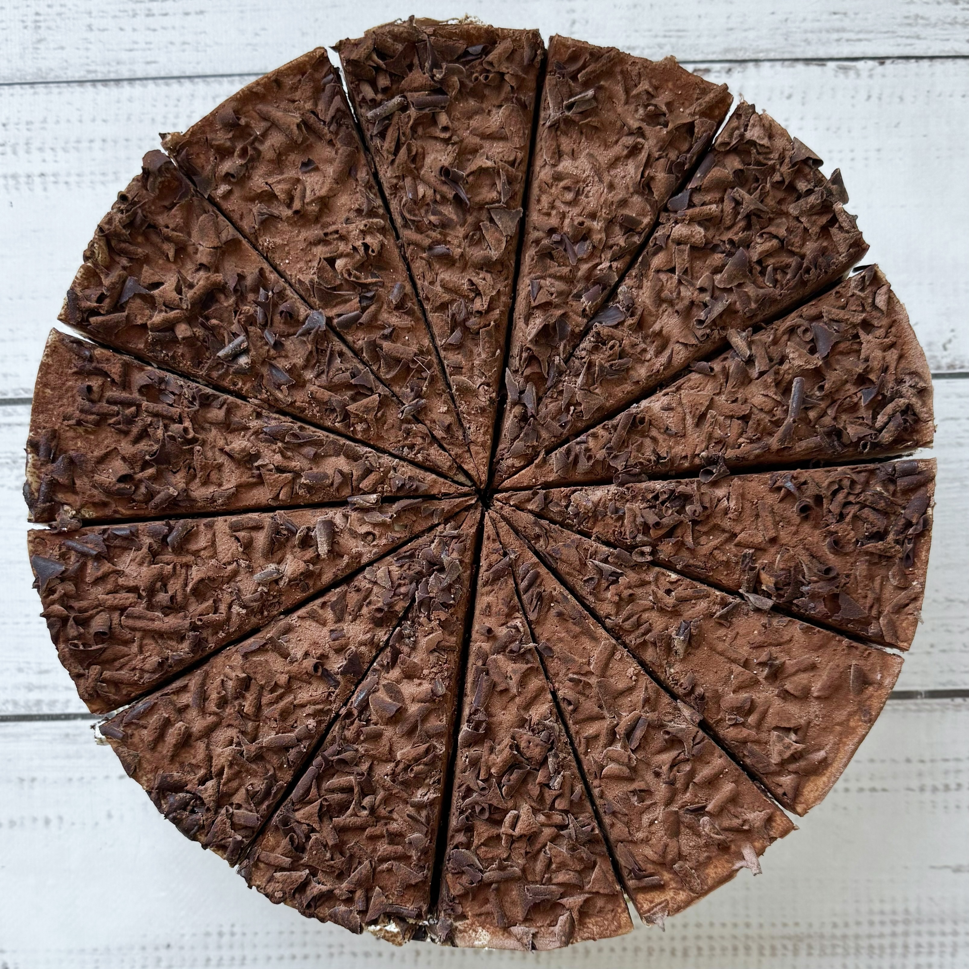 Слои шоколадного бисквита, пропитанного вишневым сиропом, чередуются со слоями крема из свежих сливок и сочных вишен. Украшен шоколадной стружкой. изображение 9