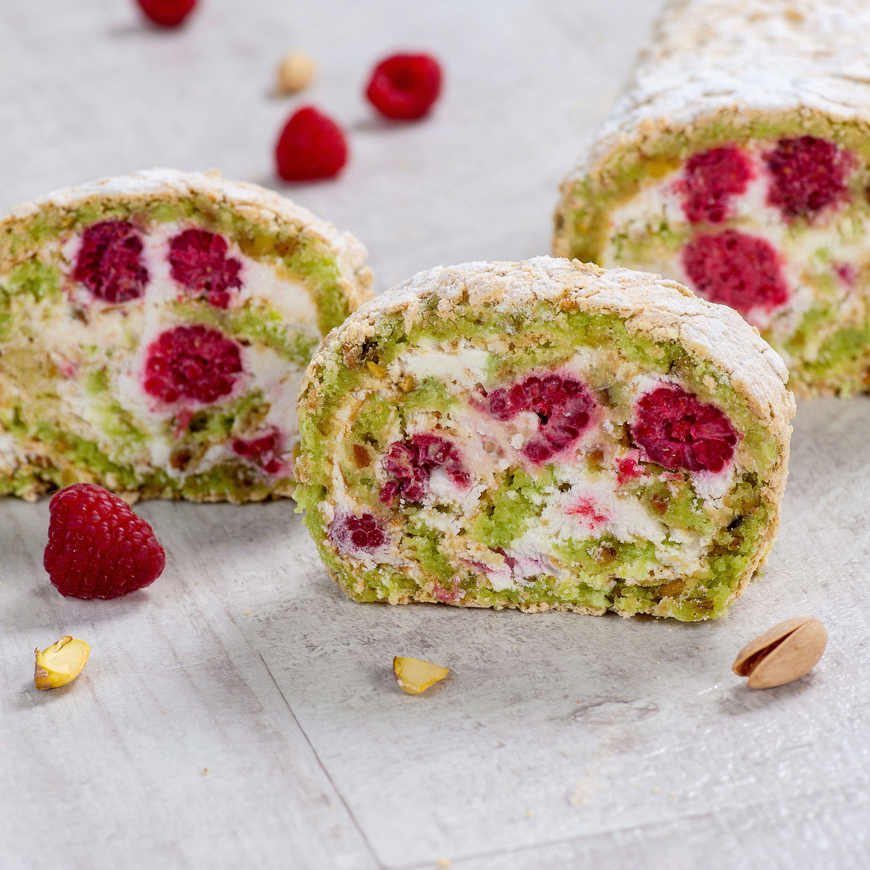 Внутри фисташкового бисквита нежный крем на основе взбитых сливок и спелая малина. Невероятно сочный вкус! Рулет украшен посыпкой из сахарной пудры. изображение 3