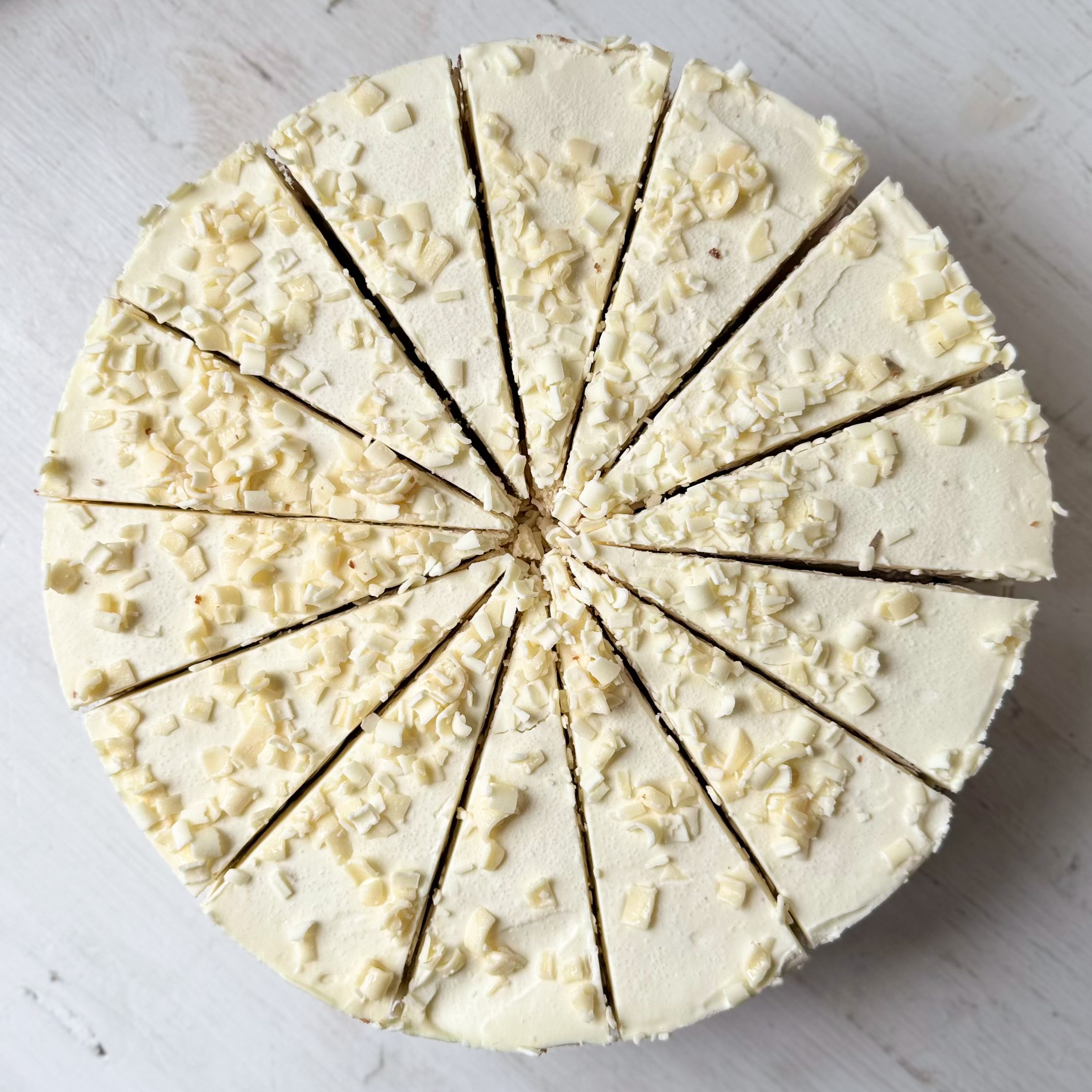 Изысканный торт из слоев нежного бисквита и творожного крема. Сверху торт украшен посыпкой из белого шоколада. изображение 2