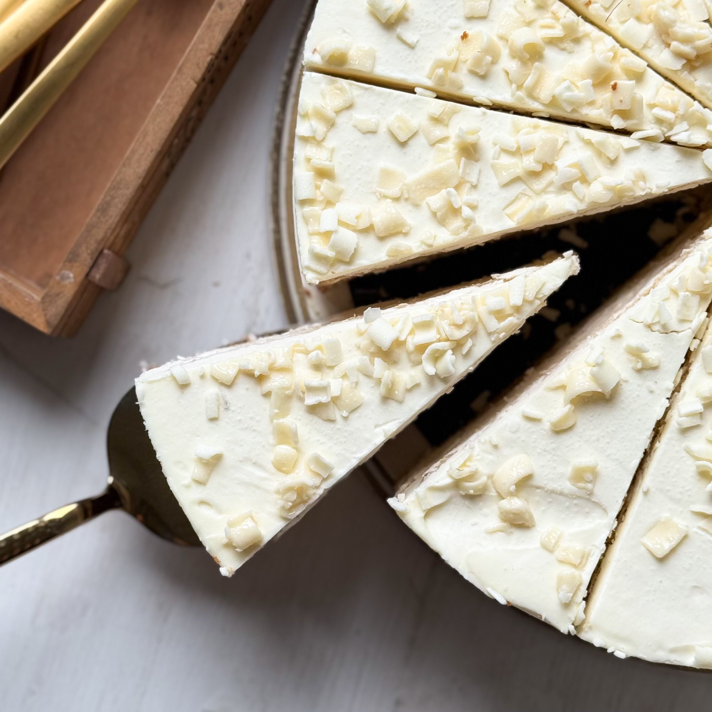 Изысканный торт из слоев нежного бисквита и творожного крема. Сверху торт украшен посыпкой из белого шоколада. изображение 4