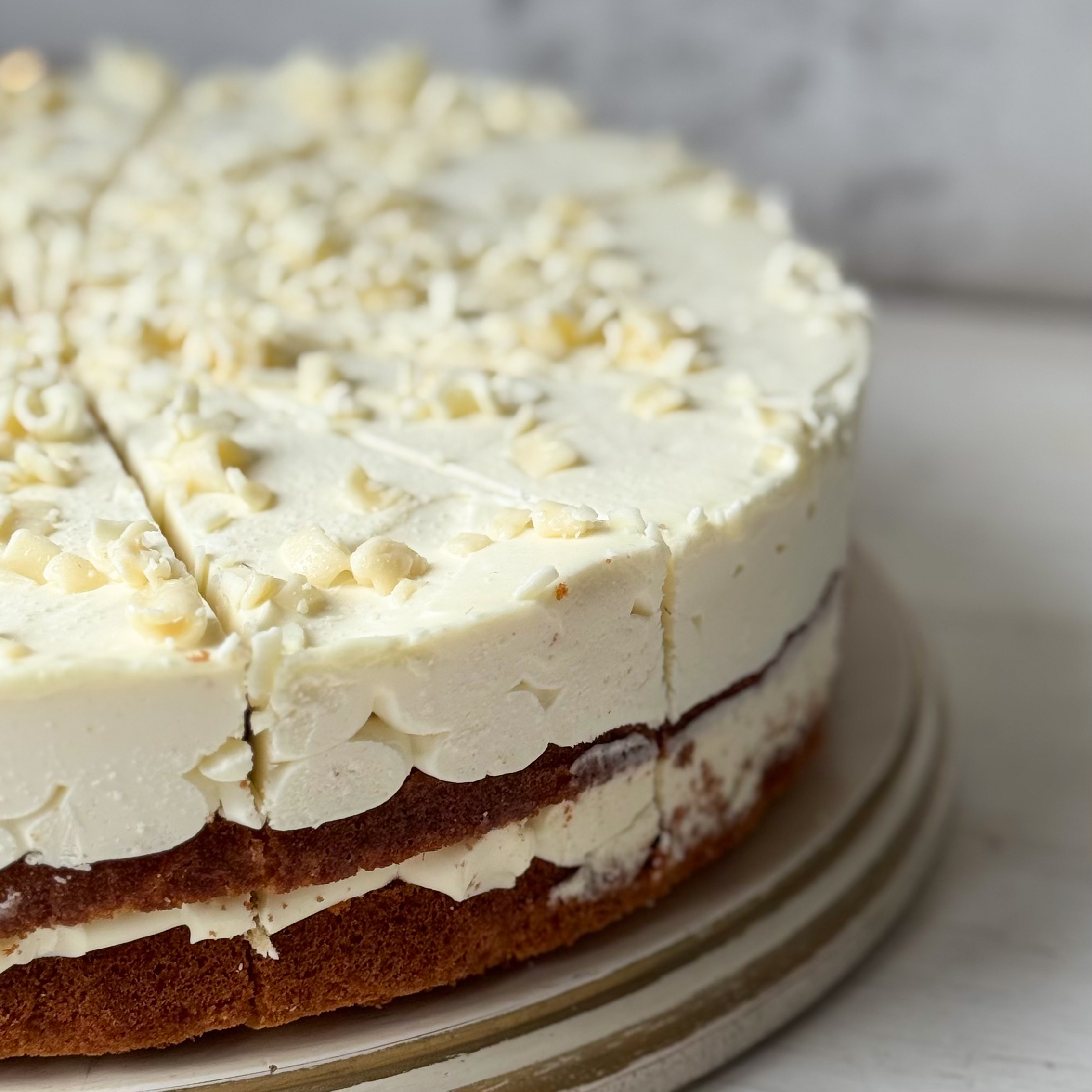 Изысканный торт из слоев нежного бисквита и творожного крема. Сверху торт украшен посыпкой из белого шоколада. изображение 5