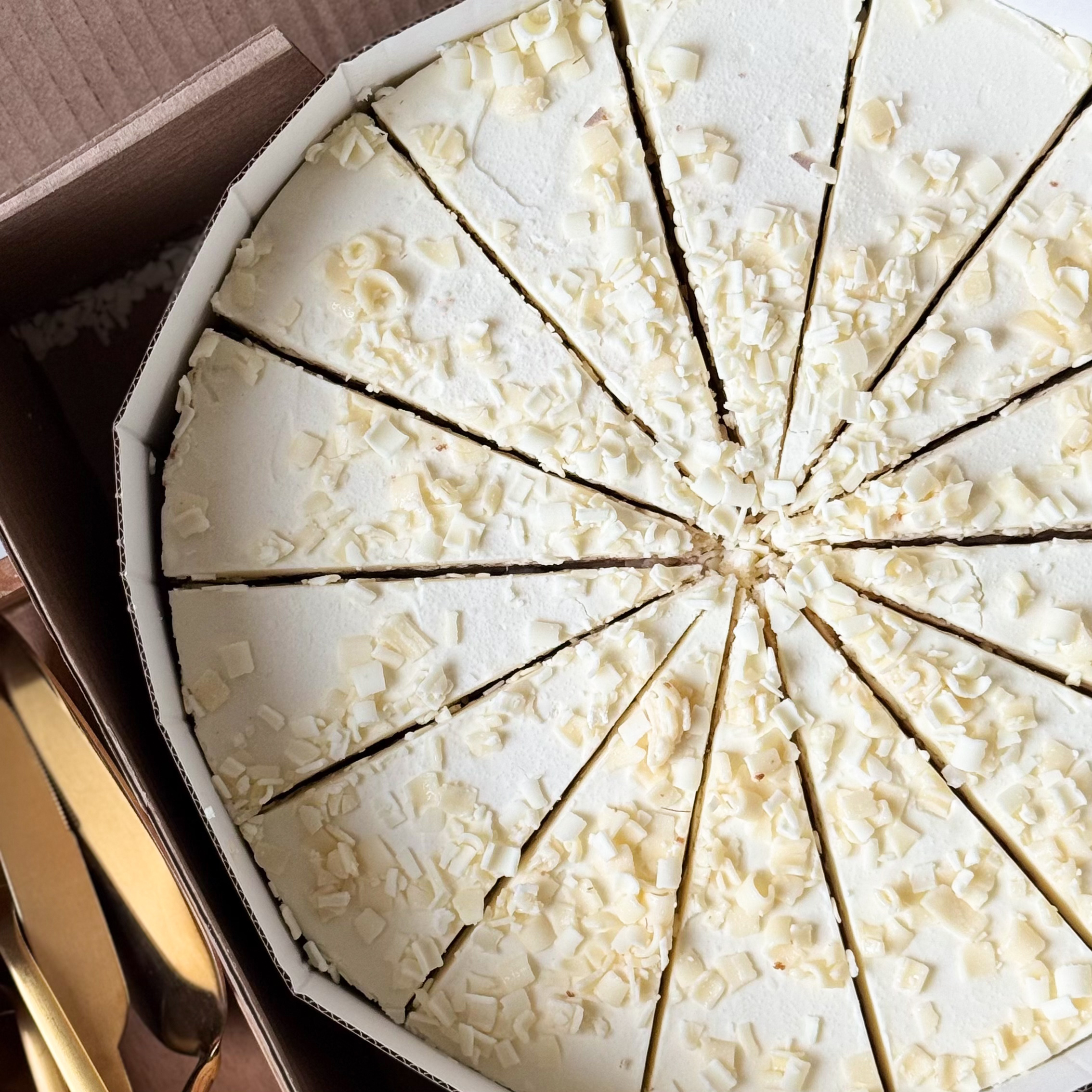 Изысканный торт из слоев нежного бисквита и творожного крема. Сверху торт украшен посыпкой из белого шоколада. изображение 6