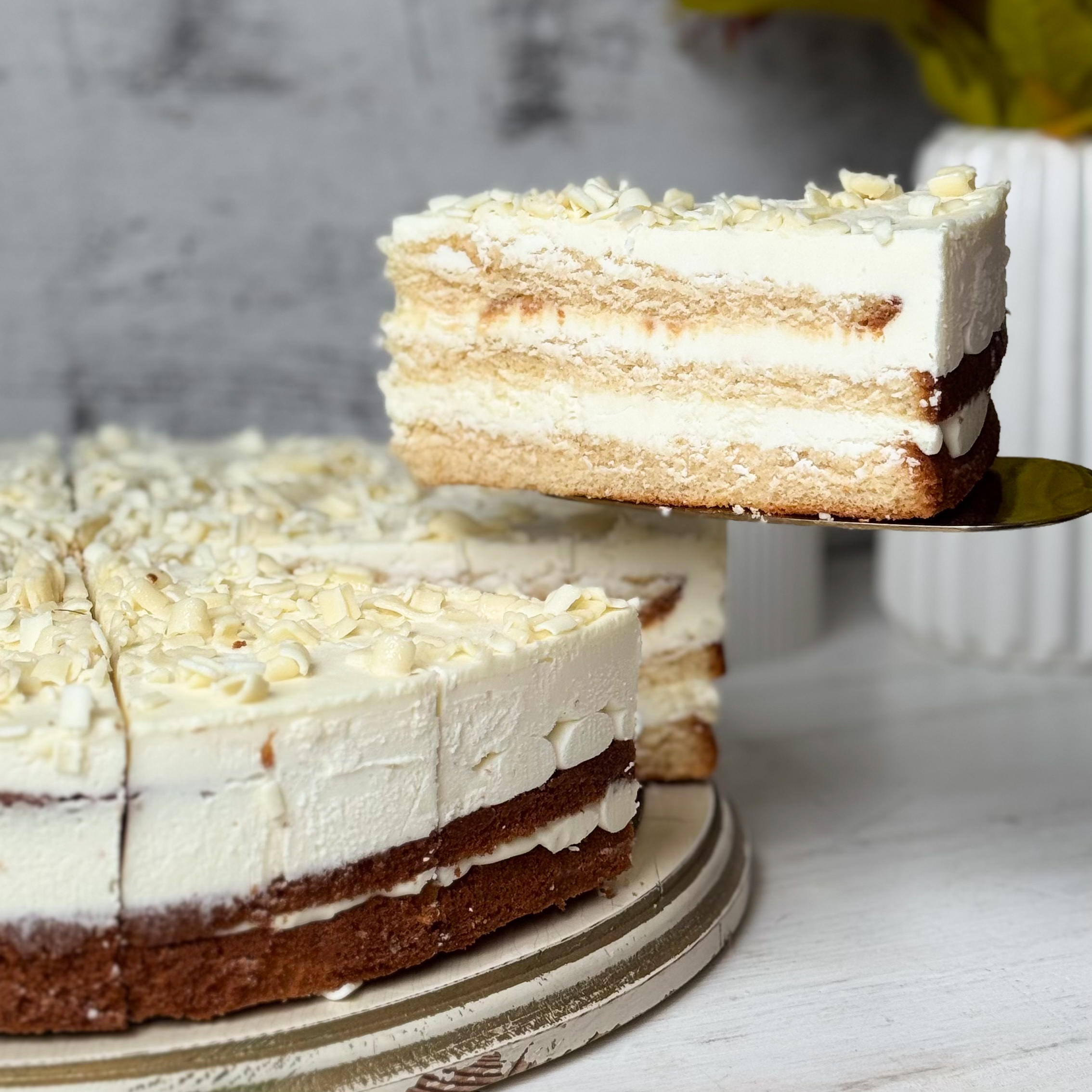 Изысканный торт из слоев нежного бисквита и творожного крема. Сверху торт украшен посыпкой из белого шоколада. изображение 7