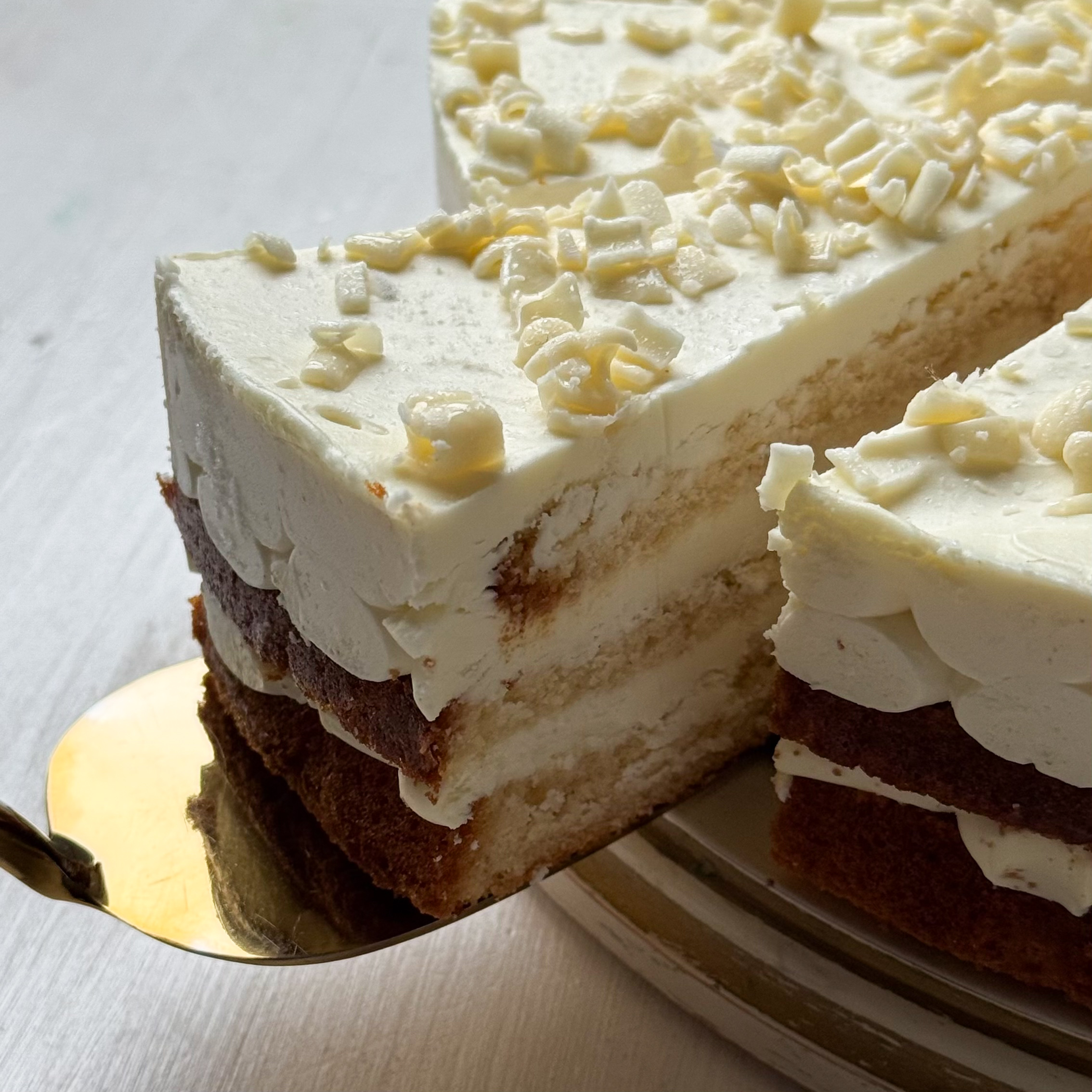 Изысканный торт из слоев нежного бисквита и творожного крема. Сверху торт украшен посыпкой из белого шоколада. изображение 9