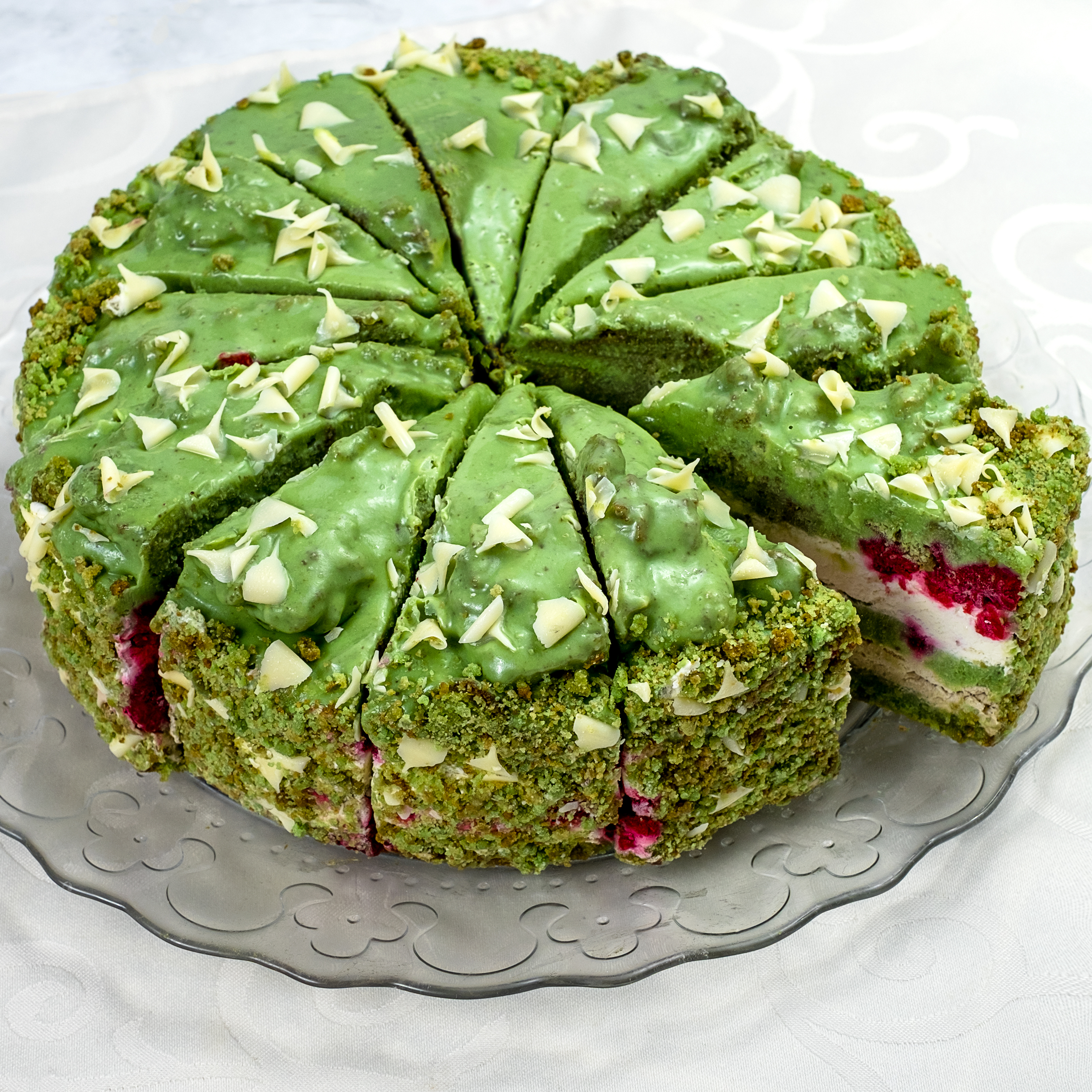 Солоноватый вкус фисташки с нежным муссом и спелой малиной - невероятно сочный торт! Сверху украшен стружкой белого шоколада.   изображение 2