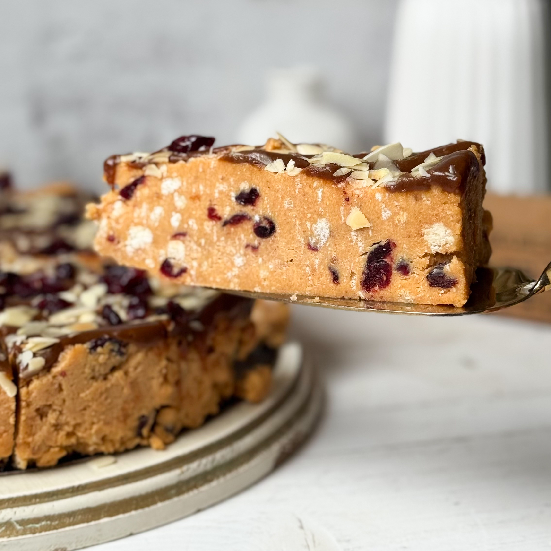 Сочный песочно-карамельный торт с сушеной клюквой и кусочками печенья. Сверху торт украшен волнами мягкой карамели, лепестками миндаля и клюквой.  изображение 11