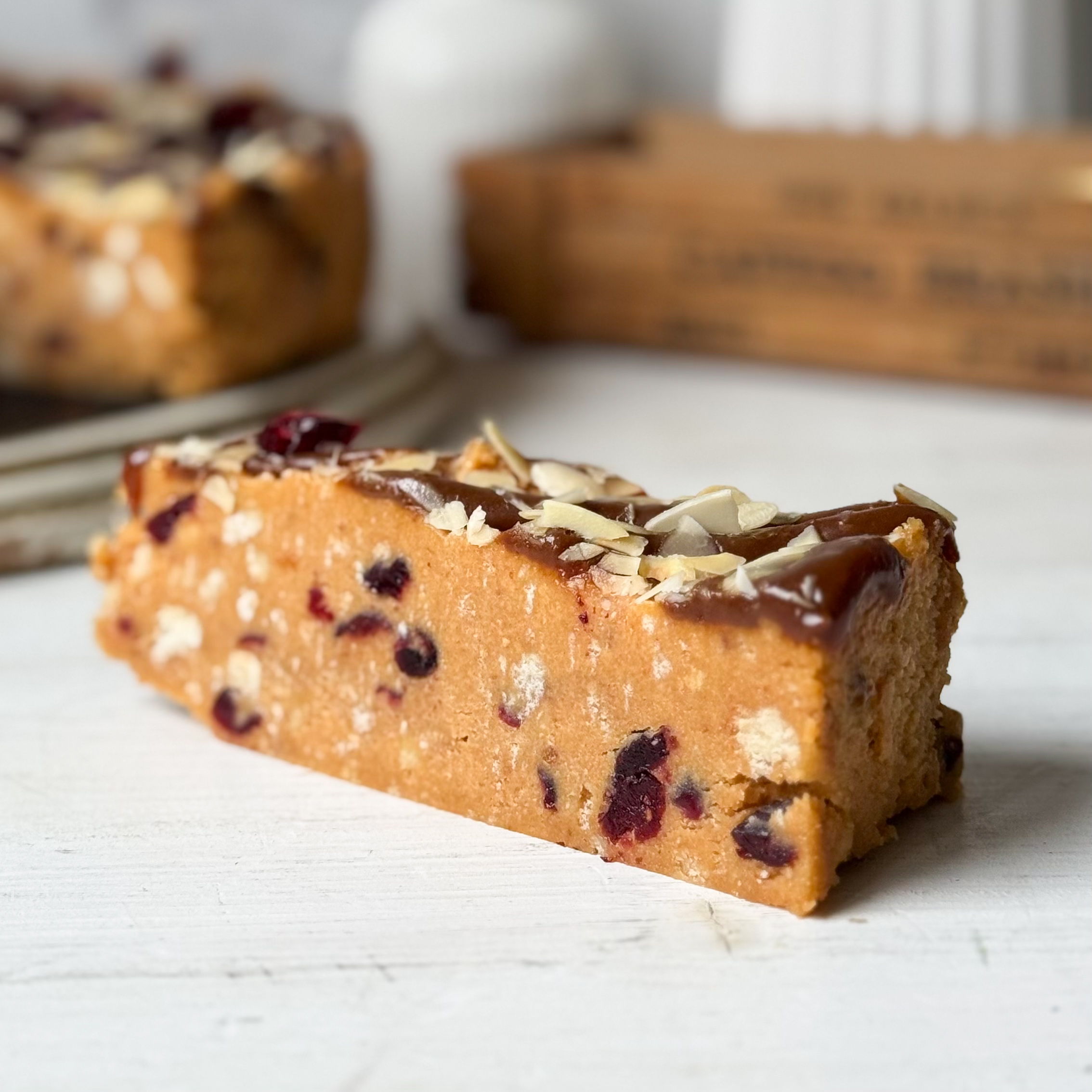 Сочный песочно-карамельный торт с сушеной клюквой и кусочками печенья. Сверху торт украшен волнами мягкой карамели, лепестками миндаля и клюквой.  изображение 4