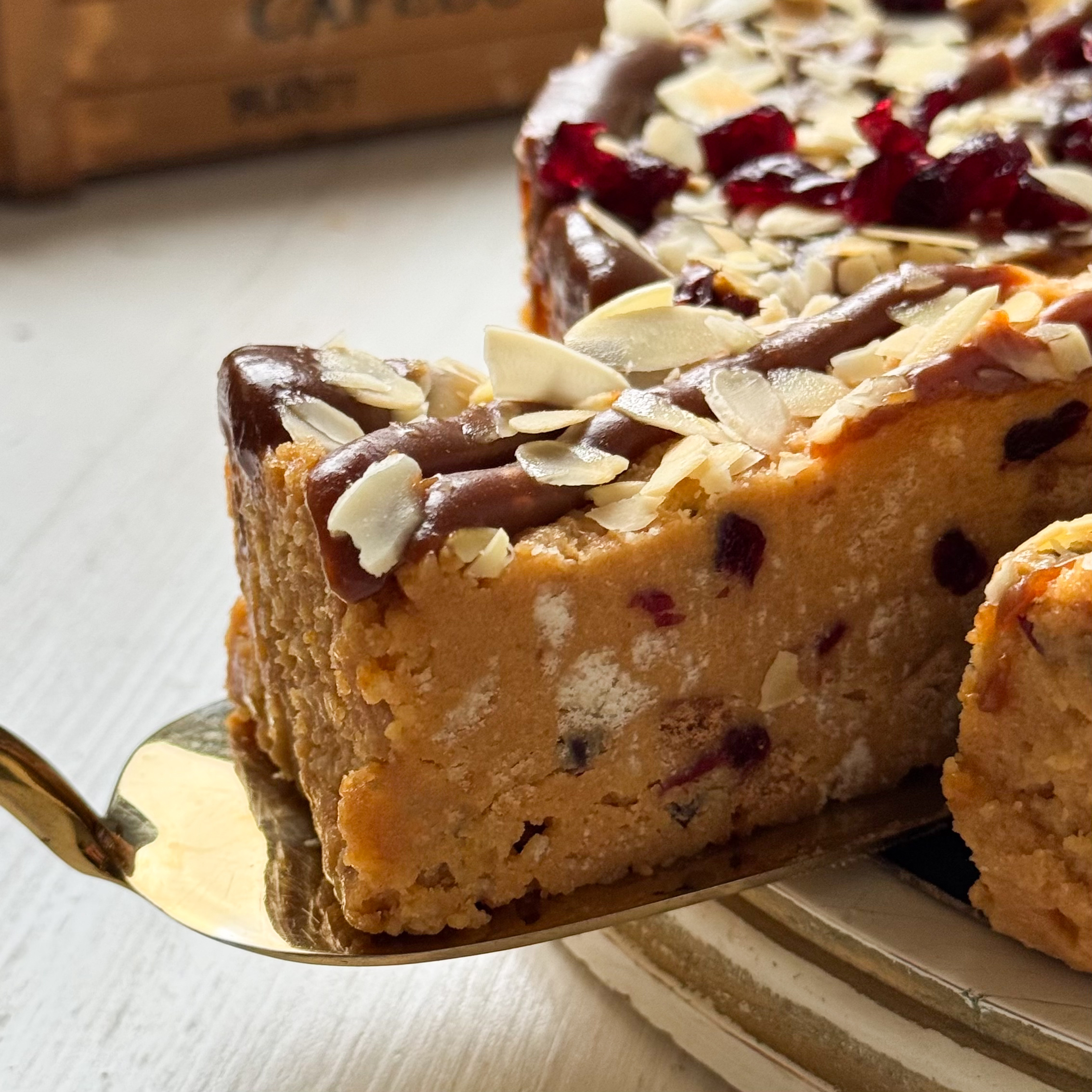 Сочный песочно-карамельный торт с сушеной клюквой и кусочками печенья. Сверху торт украшен волнами мягкой карамели, лепестками миндаля и клюквой.  изображение 5