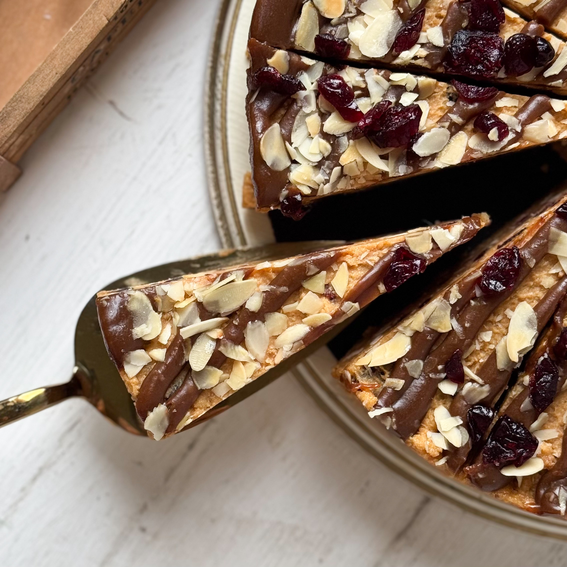 Сочный песочно-карамельный торт с сушеной клюквой и кусочками печенья. Сверху торт украшен волнами мягкой карамели, лепестками миндаля и клюквой.  изображение 7