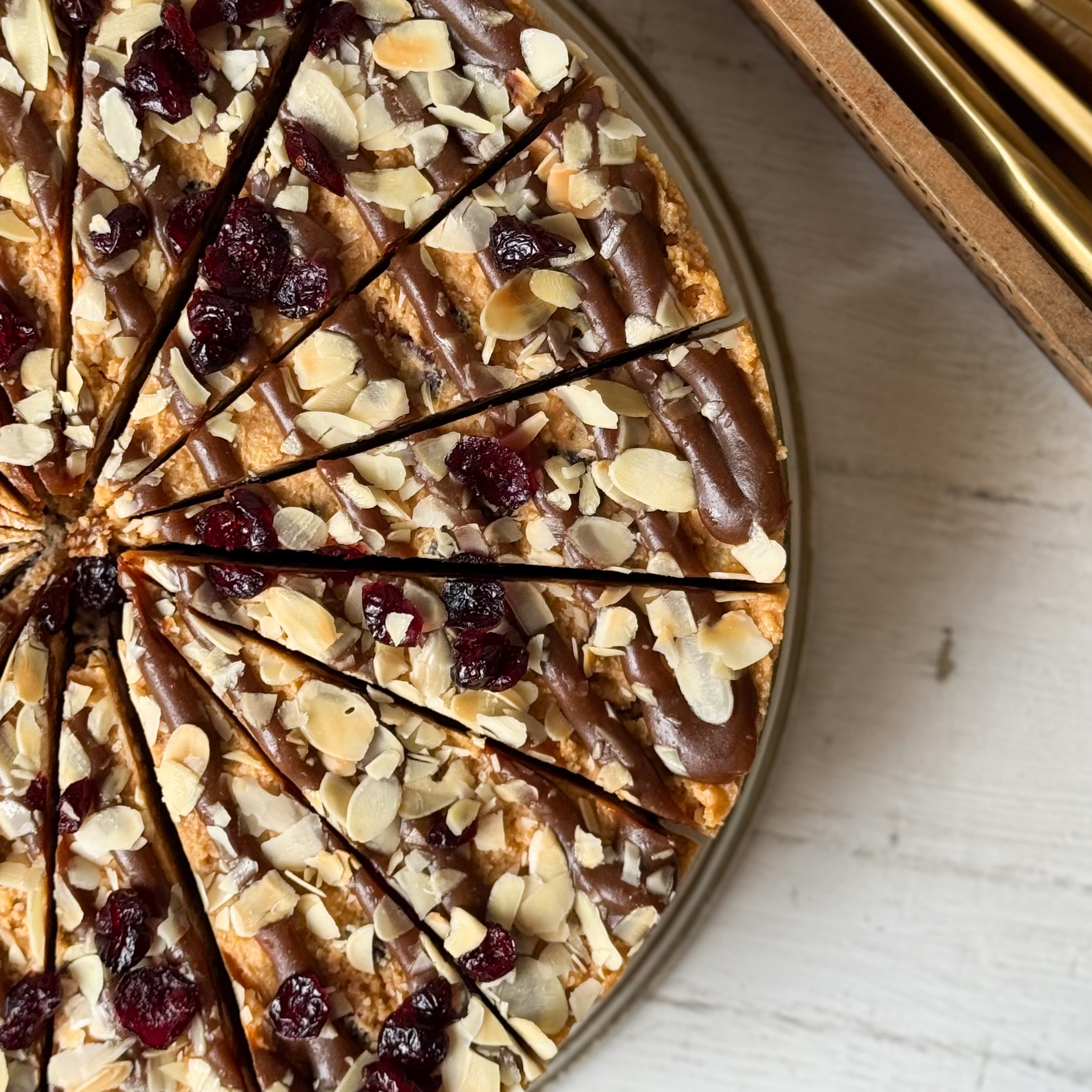 Сочный песочно-карамельный торт с сушеной клюквой и кусочками печенья. Сверху торт украшен волнами мягкой карамели, лепестками миндаля и клюквой.  изображение 8