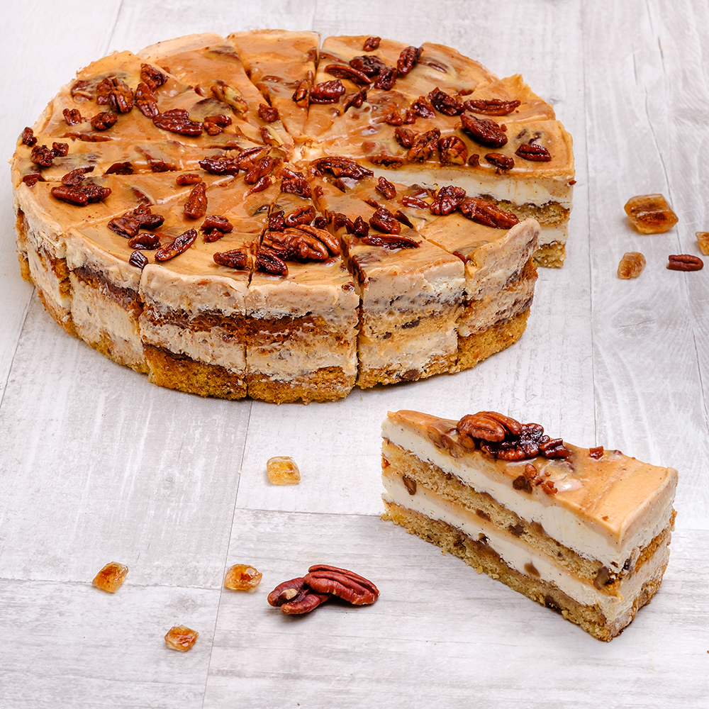 Между воздушных бисквитов с грецкими орехами две прослойки из нежного крема с корицей и карамелью. Сверху полит толстым слоем карамели с корицей и украшен горстью грецких орехов.  изображение 3