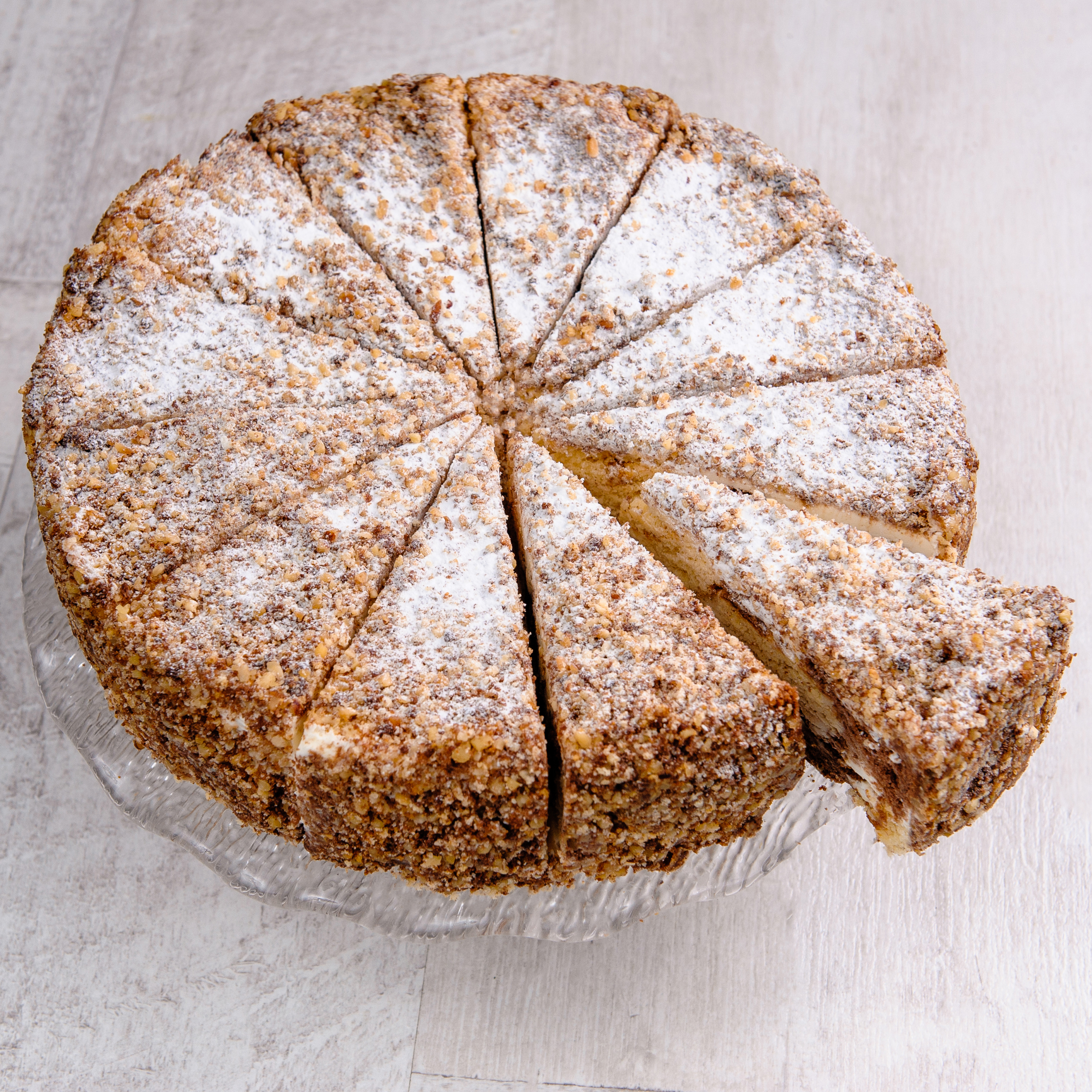 Белый и шоколадный бисквиты, прослоенные сметанным кремом. Торт украшен дроблёным орехом. изображение 3