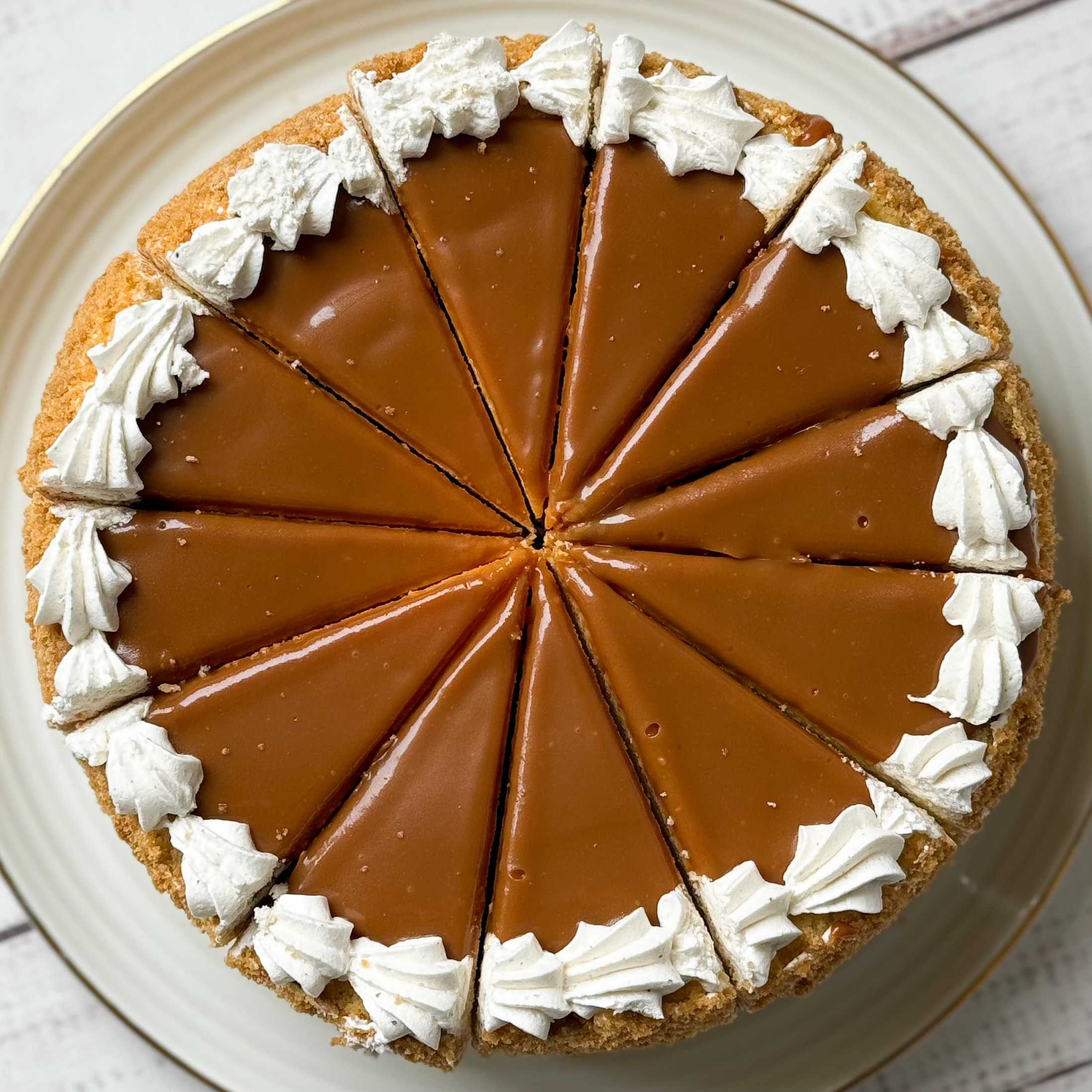 Бисквитный ванильный торт со слоем соленой хрустящей карамели и сливочного крема с молотыми стручками бурбонской ванили, покрыт толстым слоем карамели. изображение 2