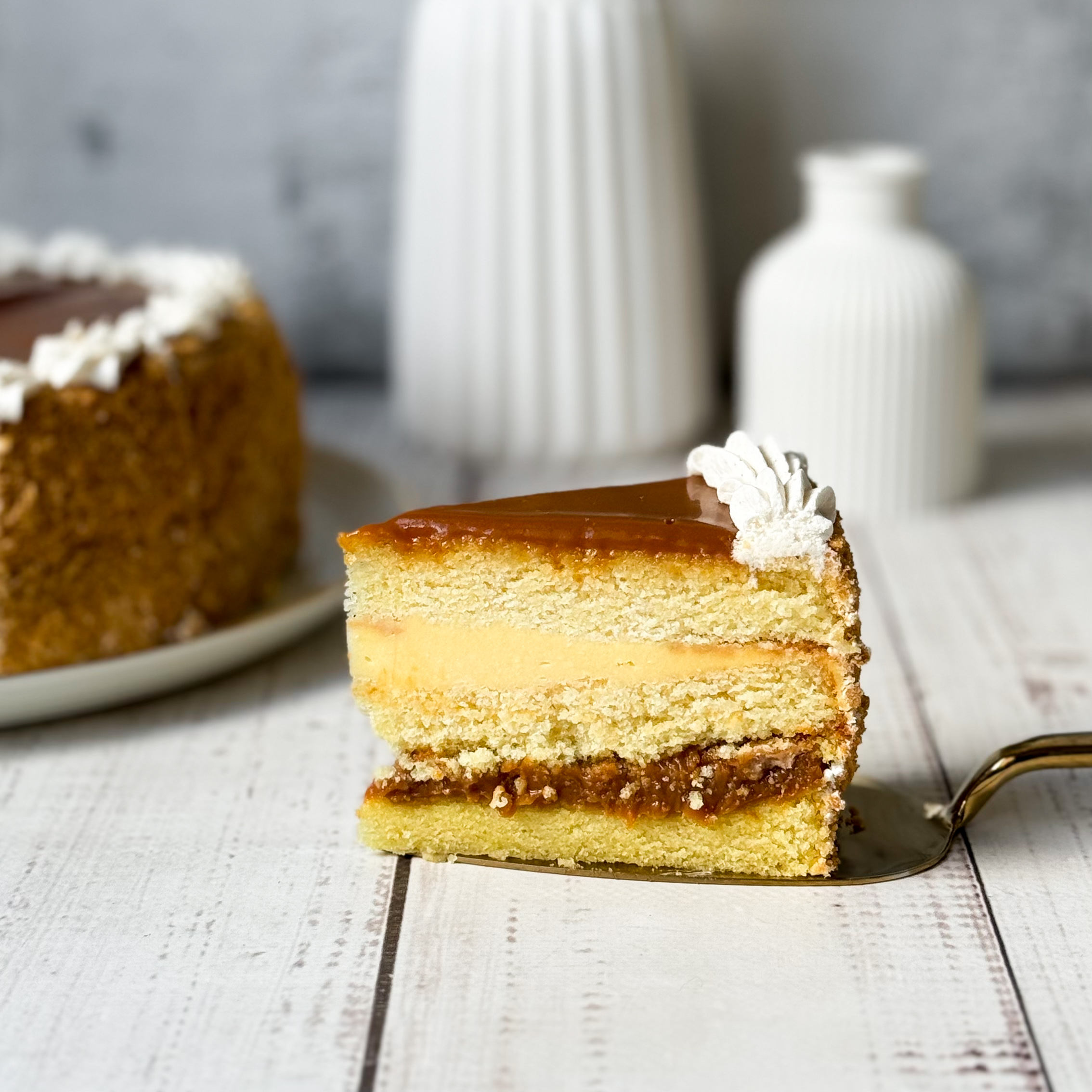 Бисквитный ванильный торт со слоем соленой хрустящей карамели и сливочного крема с молотыми стручками бурбонской ванили, покрыт толстым слоем карамели. изображение 4