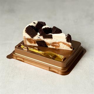 Нежный чизкейк с карамелью и кусочками из брауни. Сверху украшено шоколадом.