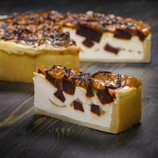 Нежный чизкейк с карамелью и кусочками из брауни. Сверху украшено шоколадом.