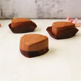 Десерт изысканной формы из сливочного мороженого с темным бельгийским шоколадом, посыпанного какао-пудрой