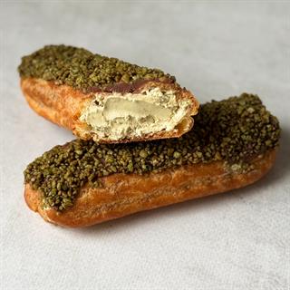 Эклер, вдохновлённый популярным лакомством арабских стран, с кремом из взбитых сливок, покрытый шоколадом и посыпкой "Дубайский шоколад"