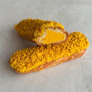 Эклер с начинкой из пюре маракуйи, манго и кремом из взбитых сливок, покрытый помадкой и посыпкой с тропическим вкусом