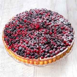 Подложка из песочного теста со слоем заварного крема, украшен сверху смесью из лесных ягод.