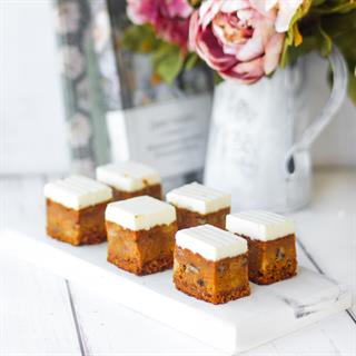 Коржи с добавлением моркови, ананаса, грецкого ореха, изюма покрыты кремом из сливочного сыра. 