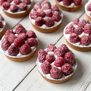 Заварной крем, взбитые сливки и спелая малина в корзиночке из песочного теста.